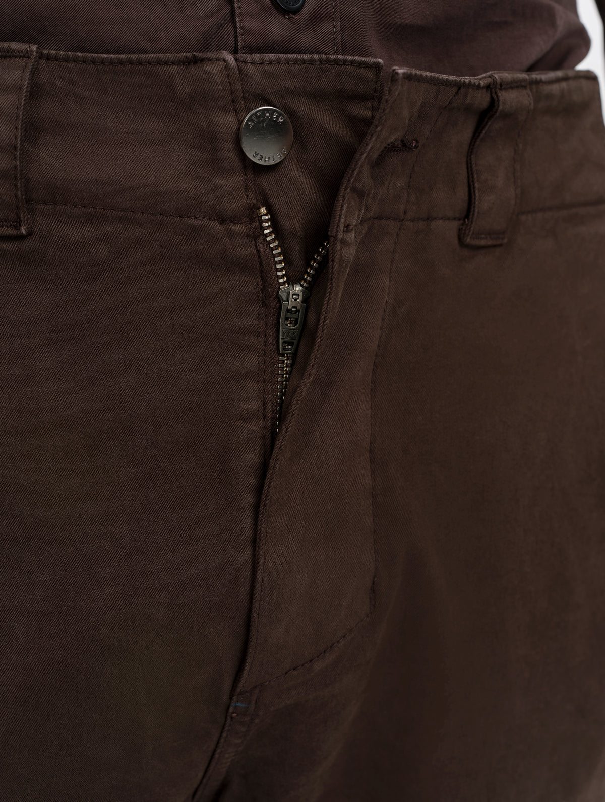 Closeup detailed view of the zippered fly and metal shank button closure on the Flint Chino Pant in Ash Brown from AETHER Apparel.