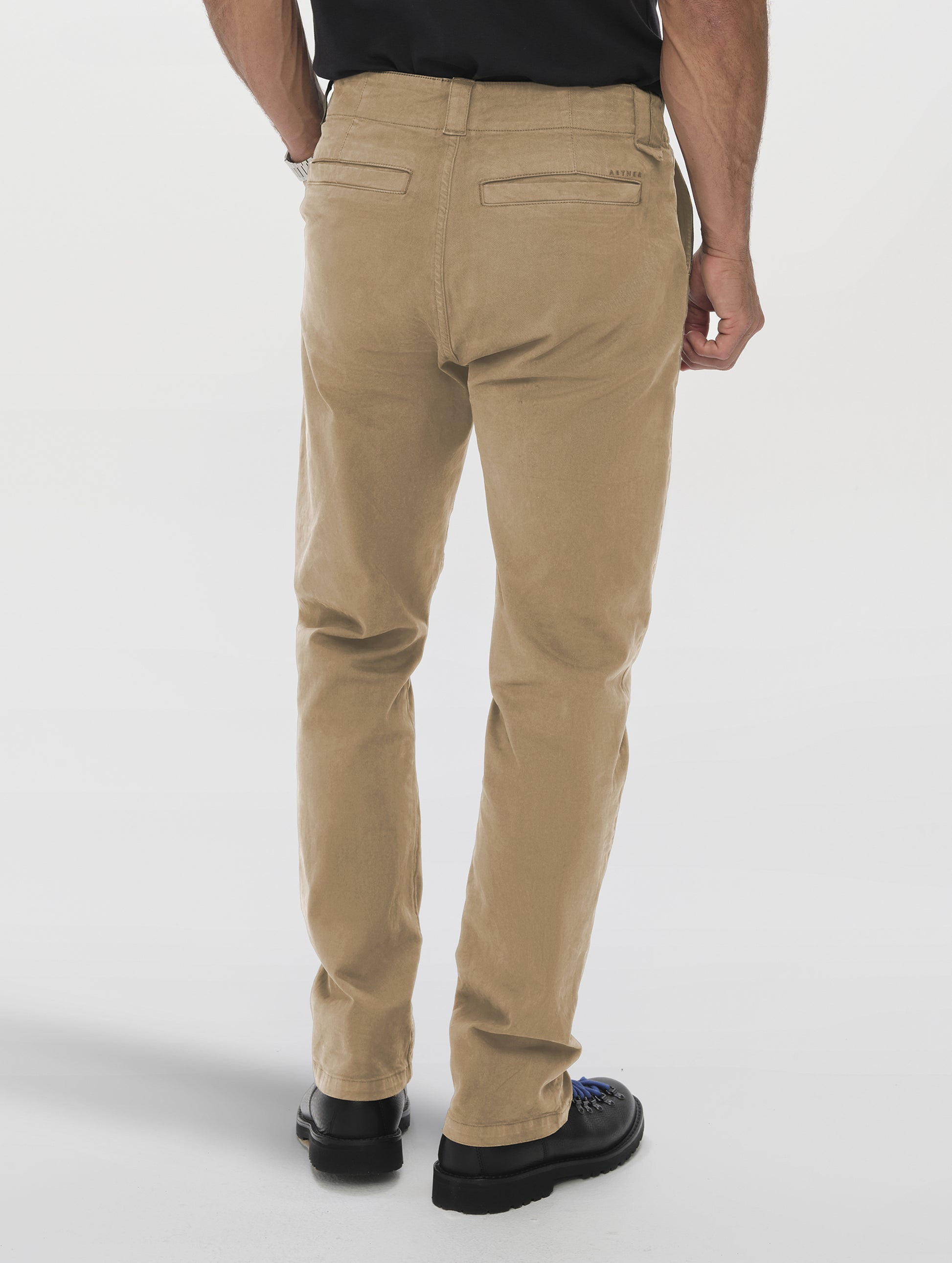 Rear lower-body view of man wearing the Flint Chino Pant in Desert Tan from AETHER Apparel.
