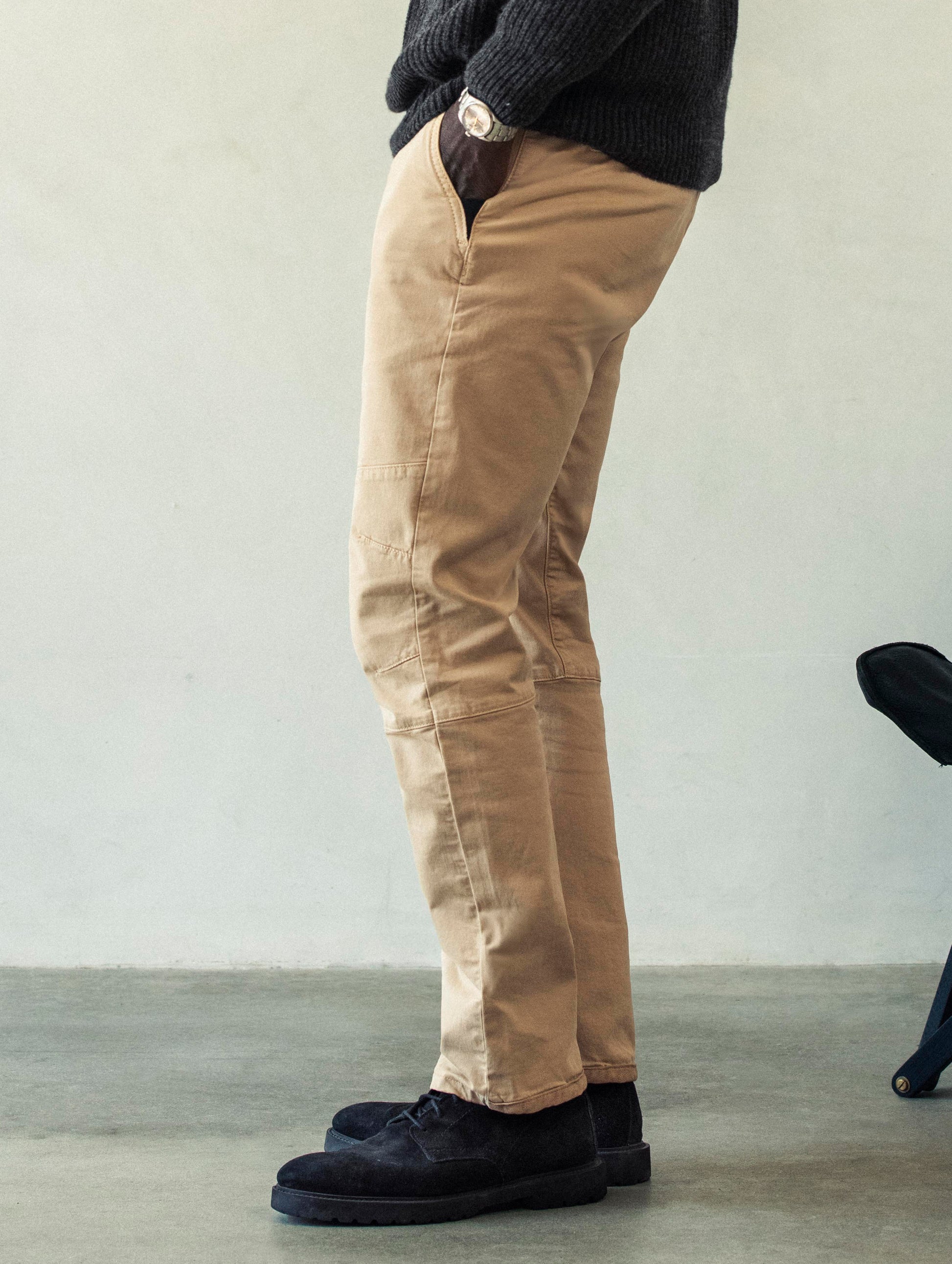 Left side profile lower body view of man wearing Gabriel Articulated Chino Stretch pant in Desert Tan from AETHER Apparel.