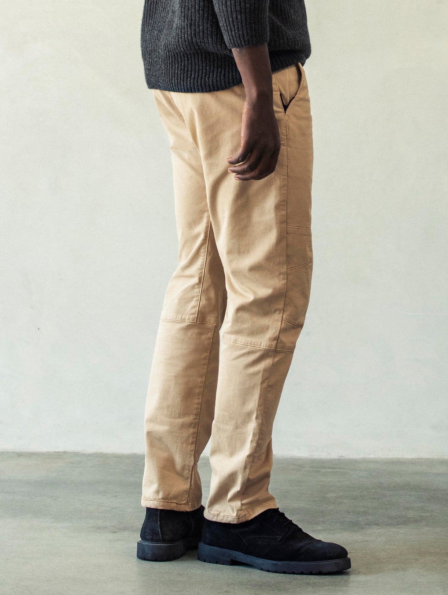 Right side profile lower body view of man wearing Gabriel Articulated Chino Stretch pant in Desert Tan from AETHER Apparel.