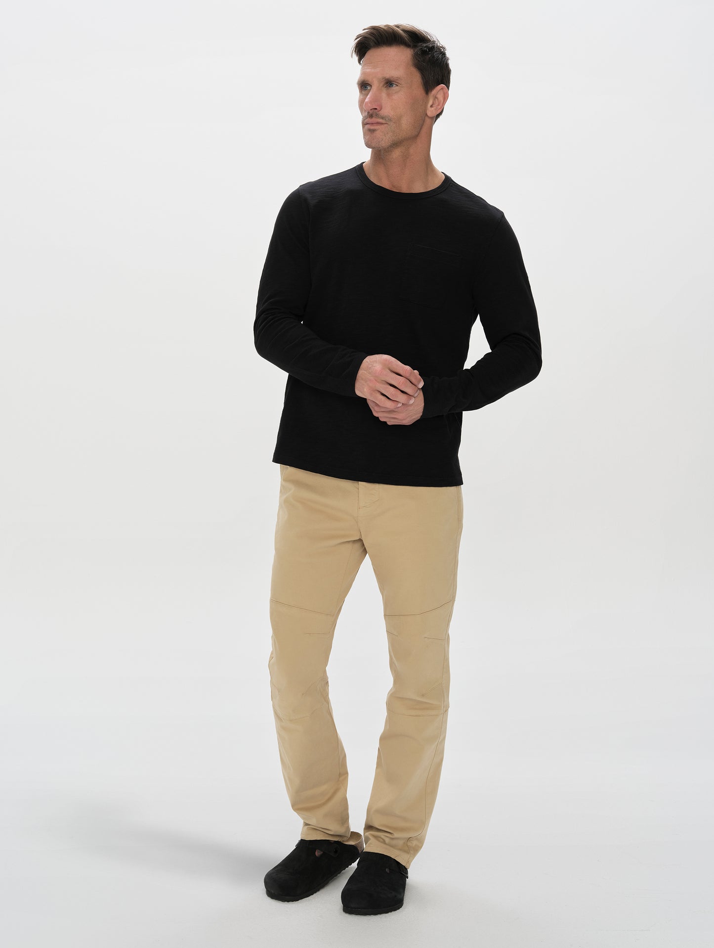 Front, full-body view of man wearing the Gabriel Articulated Chino in Desert Tan from AETHER Apparel.