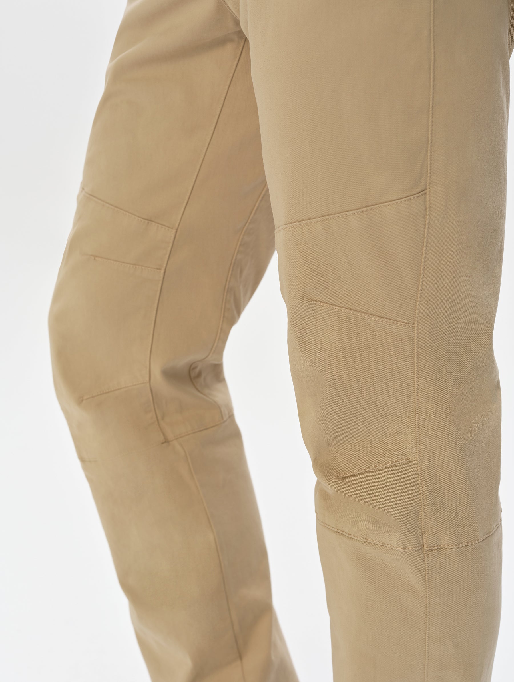 Closeup detailed view of the mobility-bolstering articulated knee darts on the Gabriel Articulated Chino in Desert Tan from AETHER Apparel.