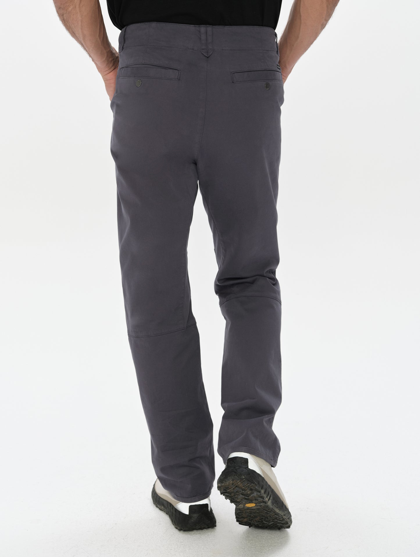 Rear, lower-body view of man wearing the Gabriel Articulated Chino in Graphite from AETHER Apparel.