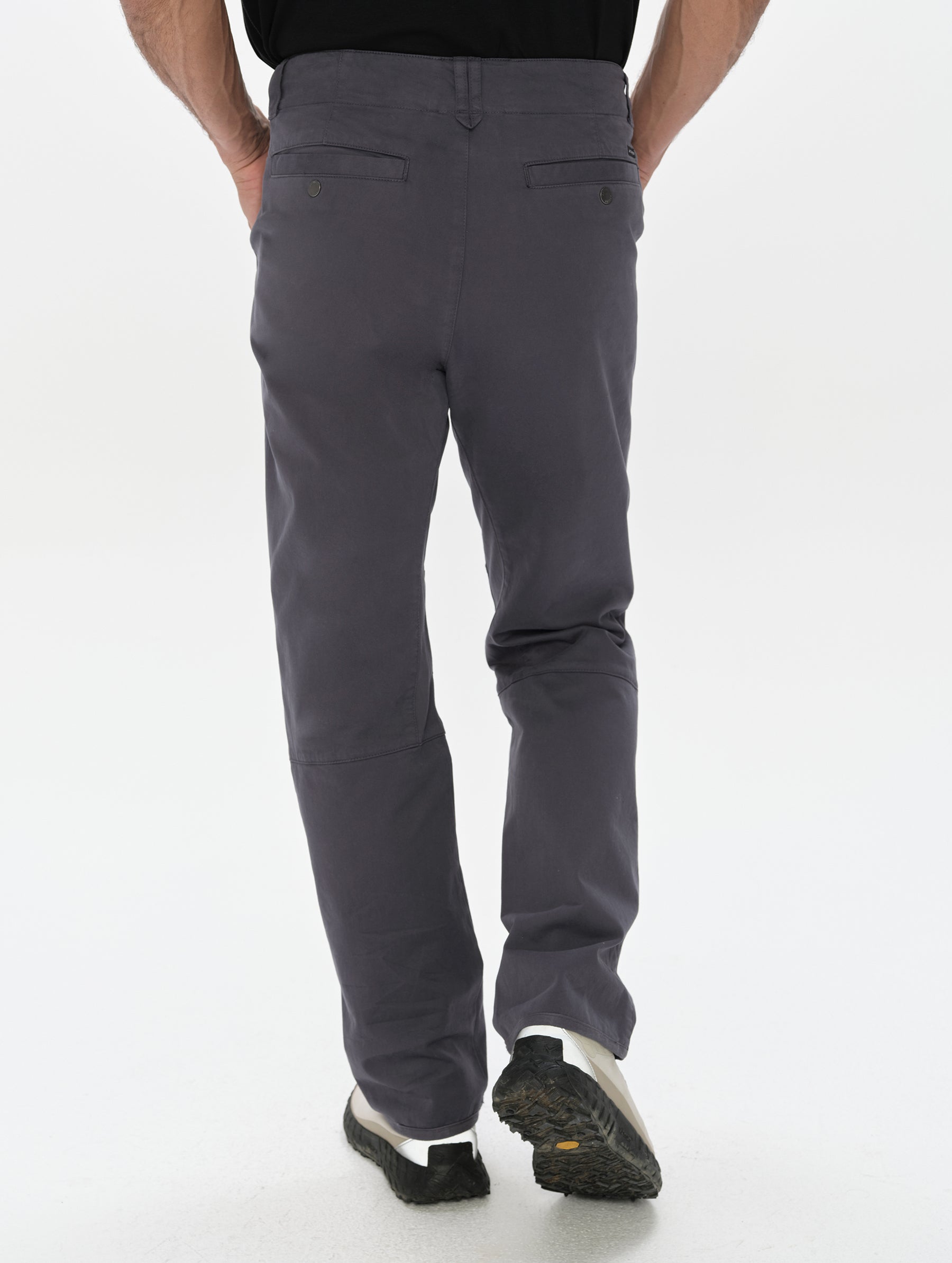Rear, lower-body view of man wearing the Gabriel Articulated Chino in Graphite from AETHER Apparel.