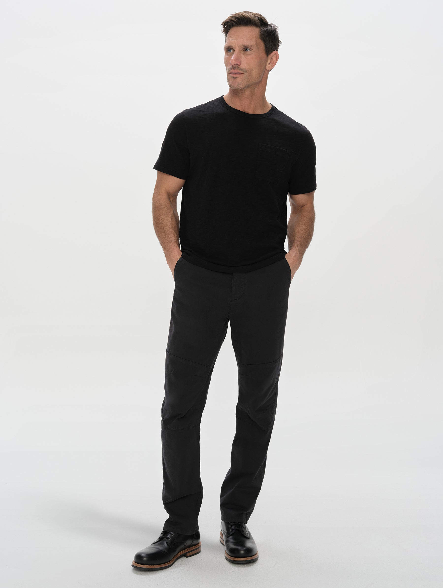 Front, full-body view of man wearing the Gabriel Articulated Chino in Onyx Black from AETHER Apparel.