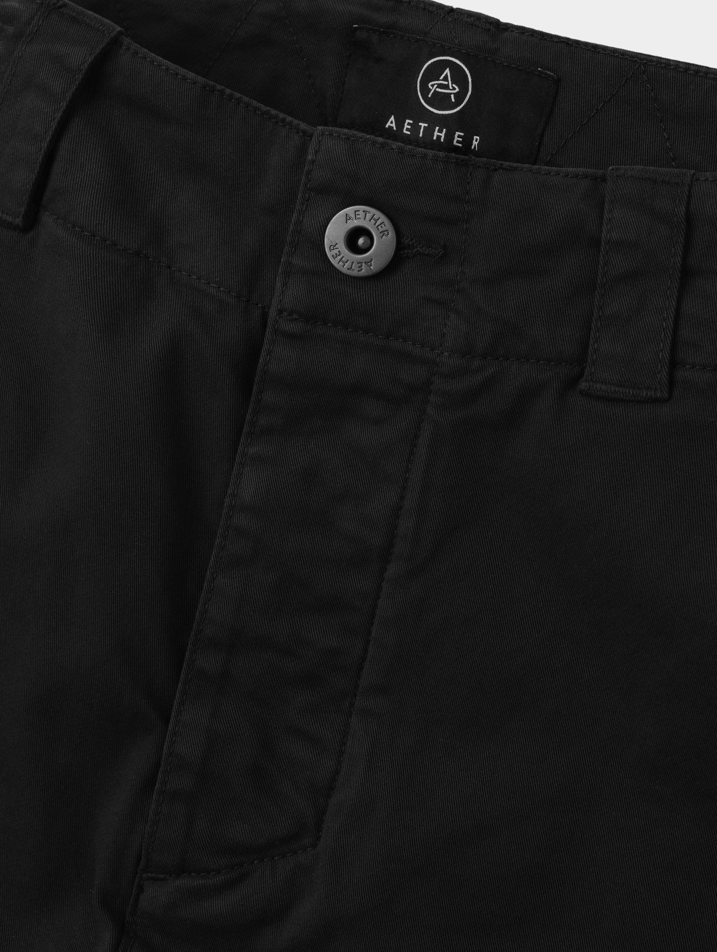 Closeup detailed view of the center-front closure on the Gabriel Articulated Chino in Onyx Black from AETHER Apparel.