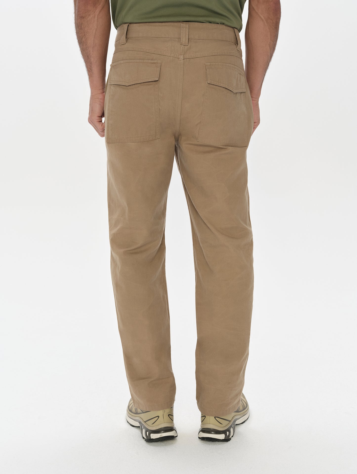 Rear, lower-body view of man wearing the Gage Cotton Pant in Desert Tan from AETHER Apparel.