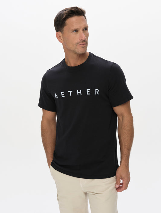 Front upper-body view of man wearing the Graphic Tee AETHER Logo in Onyx Black from AETHER Apparel.