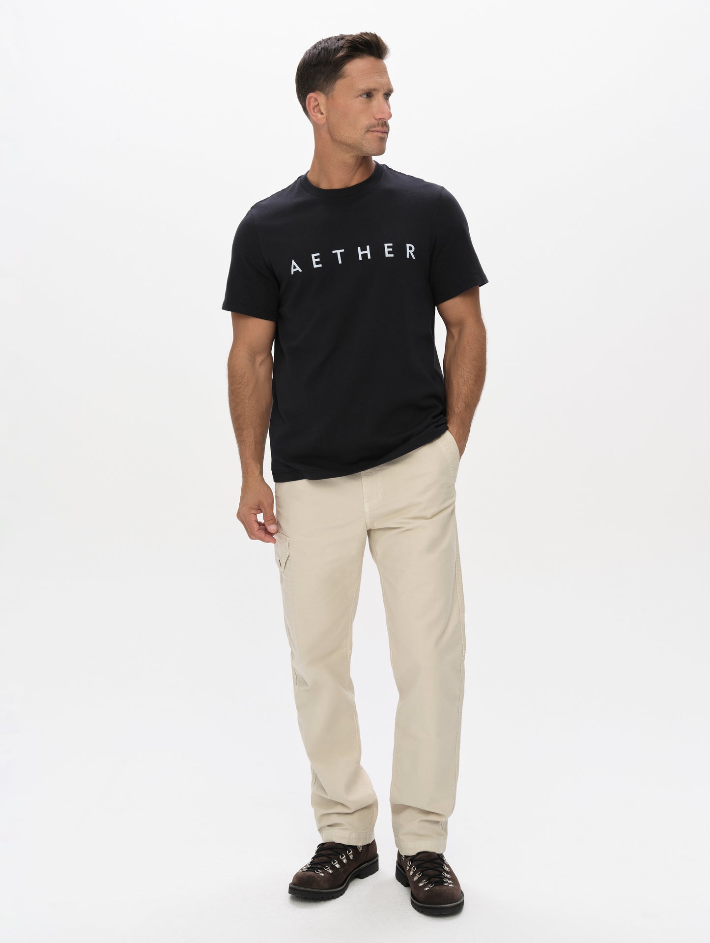 Front full-body view of man wearing the Graphic Tee AETHER Logo in Onyx Black from AETHER Apparel.