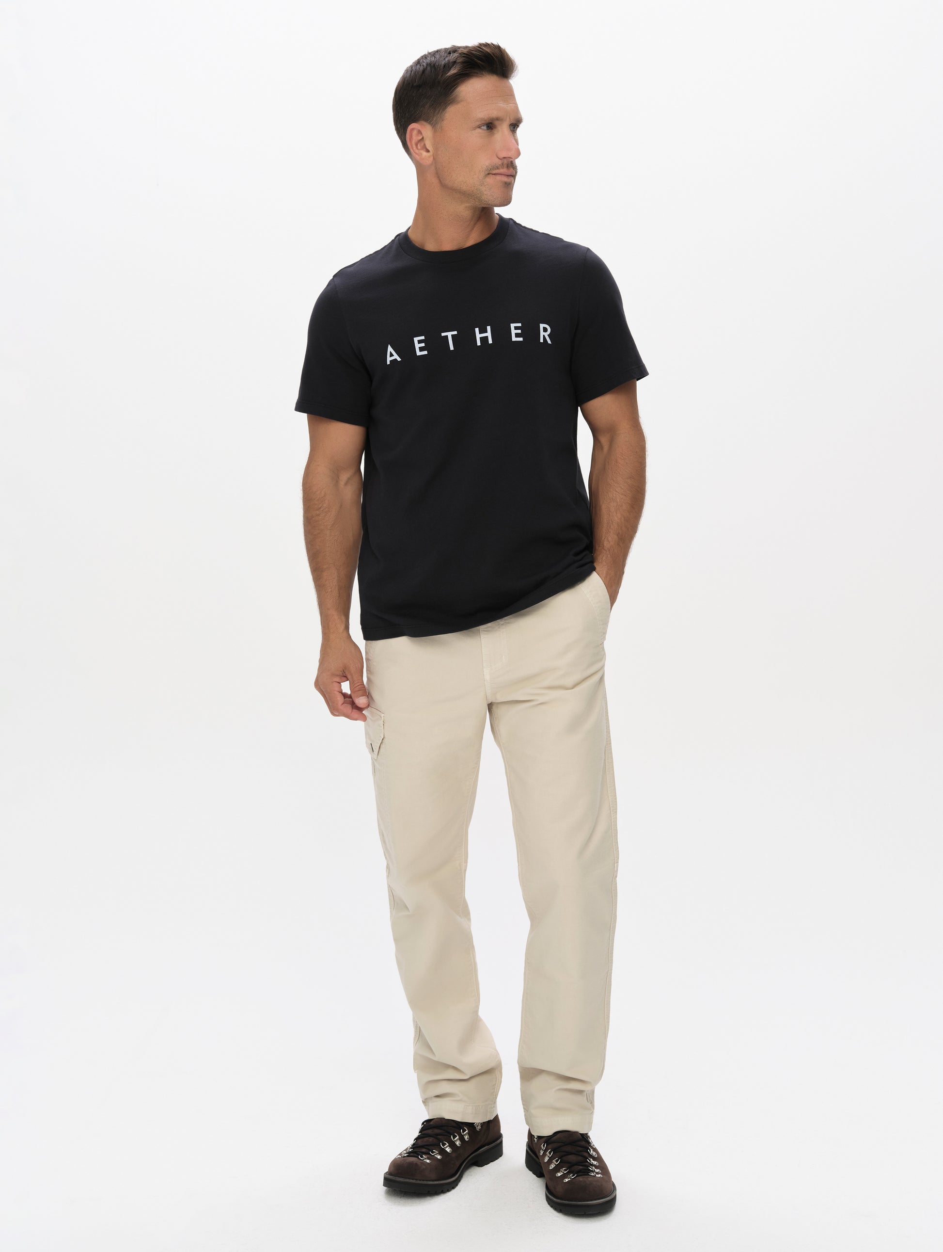 Front full-body view of man wearing the Graphic Tee AETHER Logo in Onyx Black from AETHER Apparel.