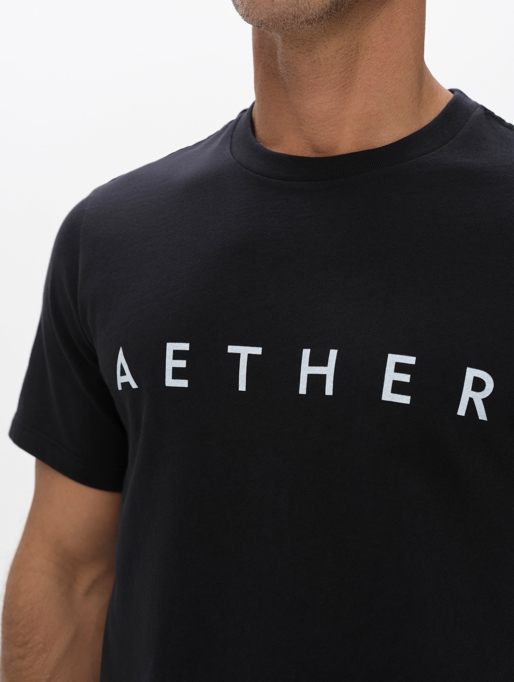 Closeup view of the screen-printed AETHER logo on the Graphic Tee AETHER Logo in Onyx Black from AETHER Apparel.