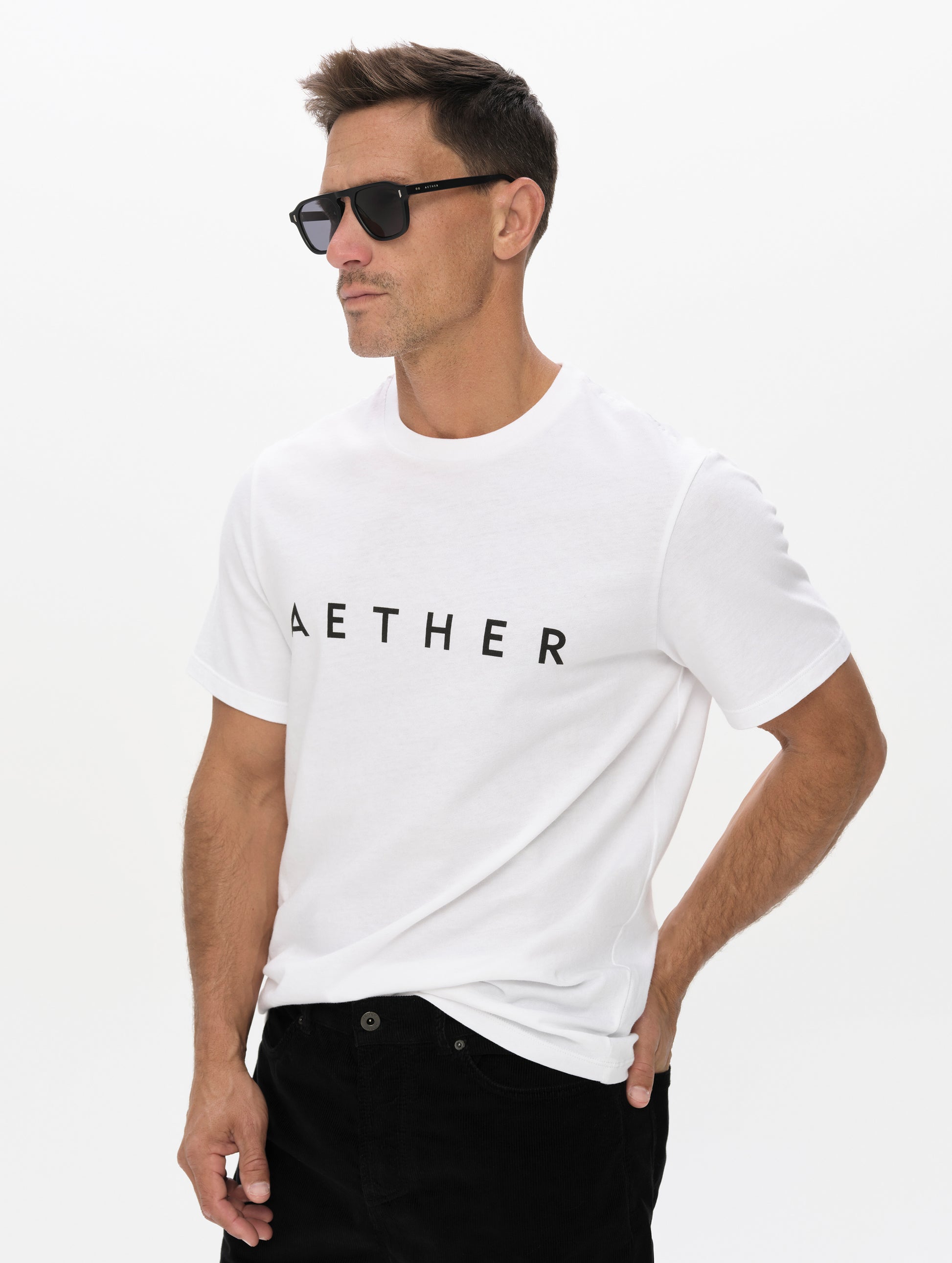 Front, angled upper-body view of man wearing the Graphic Tee AETHER Logo in White from AETHER Apparel.