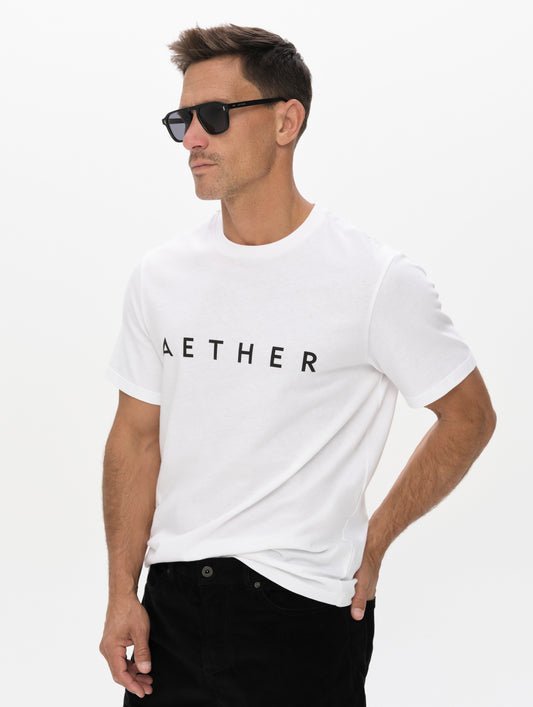 Front, angled upper-body view of man wearing the Graphic Tee AETHER Logo in White from AETHER Apparel.