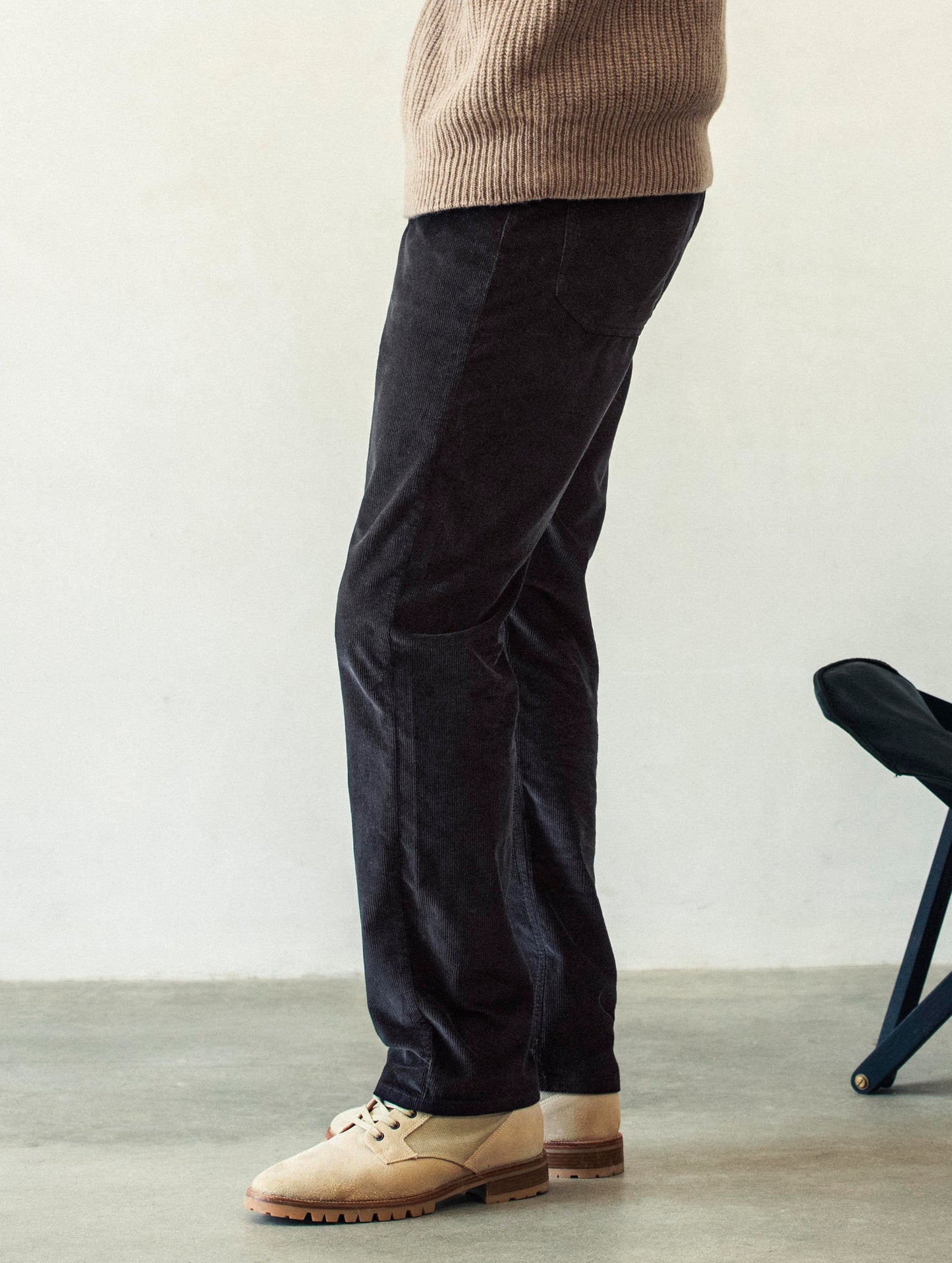 Side profile lower body view of man wearing Hayden Corduroy Pant in Tarmac Black from AETHER Apparel.