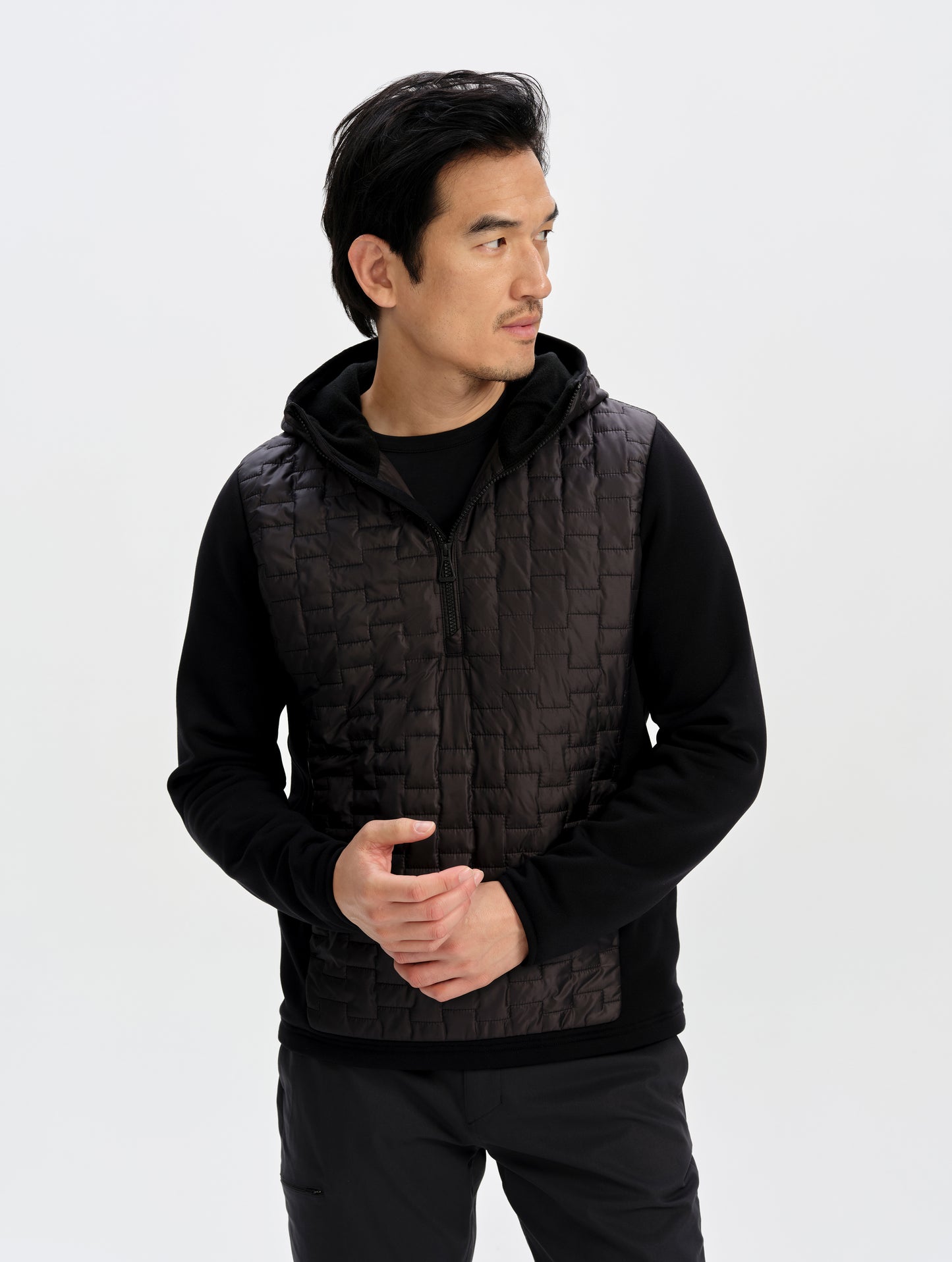 Front upper-body view of man wearing the Hybrid Tech Anorak in Onyx Black from AETHER Apparel. 