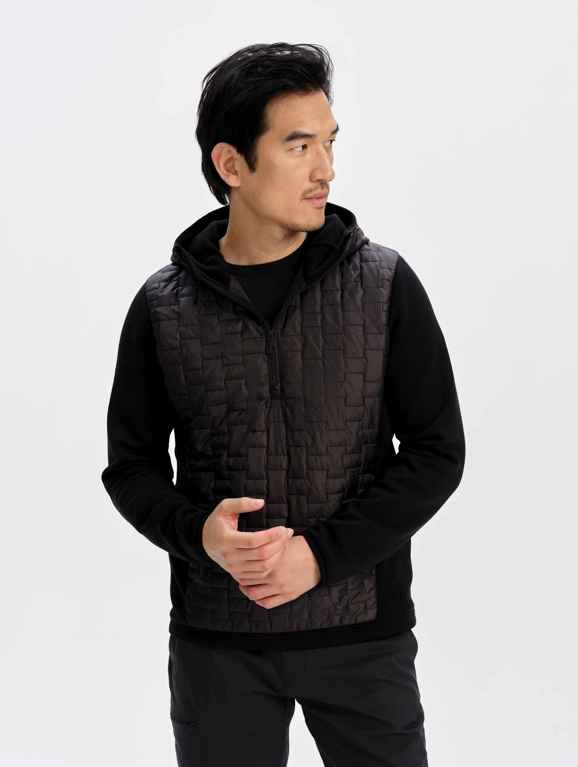 Front upper-body view of man wearing the Hybrid Tech Anorak in Onyx Black from AETHER Apparel. 