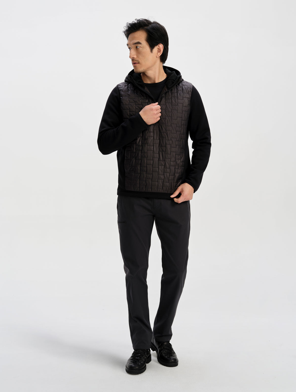 Front full-body view of man wearing the Hybrid Tech Anorak in Onyx Black from AETHER Apparel. 