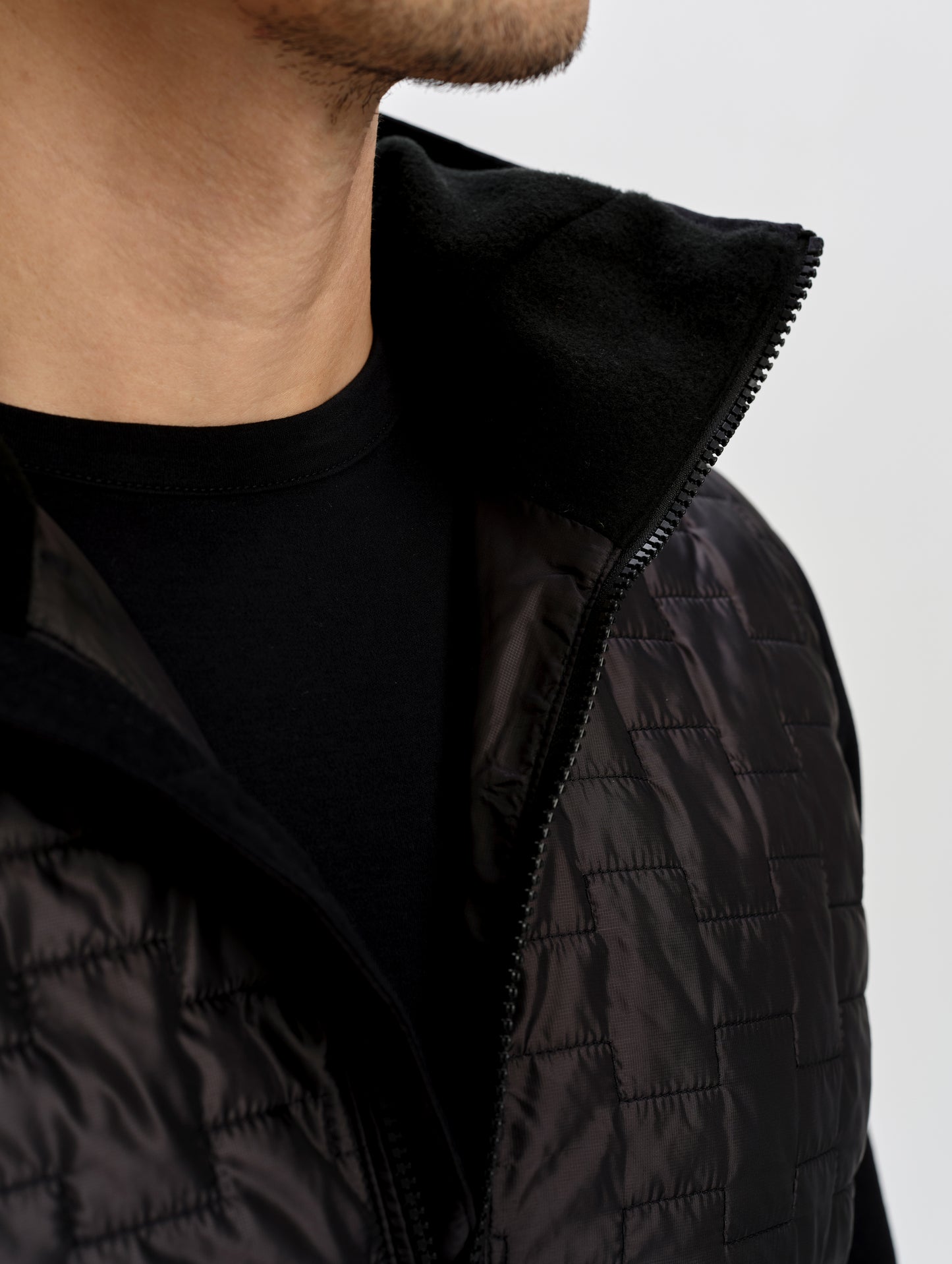 Closeup detailed view of the fleece-lined collar on the Hybrid Tech Anorak in Onyx Black from AETHER Apparel. 