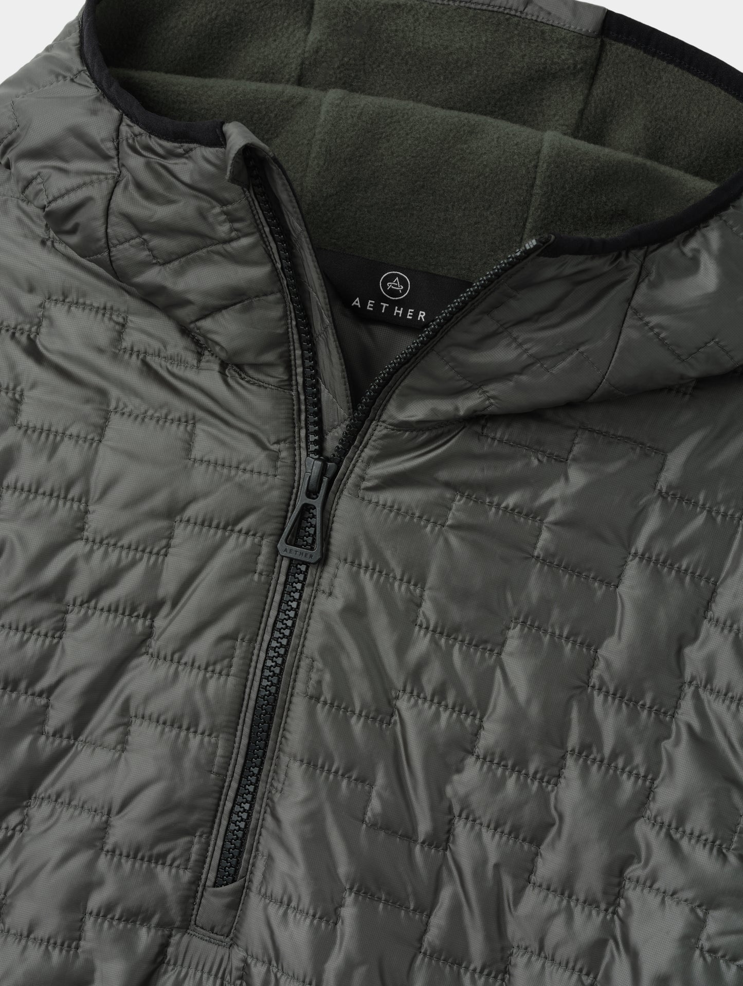 Flat lay view of the center-front zipper and fleece-lined hood on the Hybrid Tech Anorak in Saville Green from AETHER Apparel. 