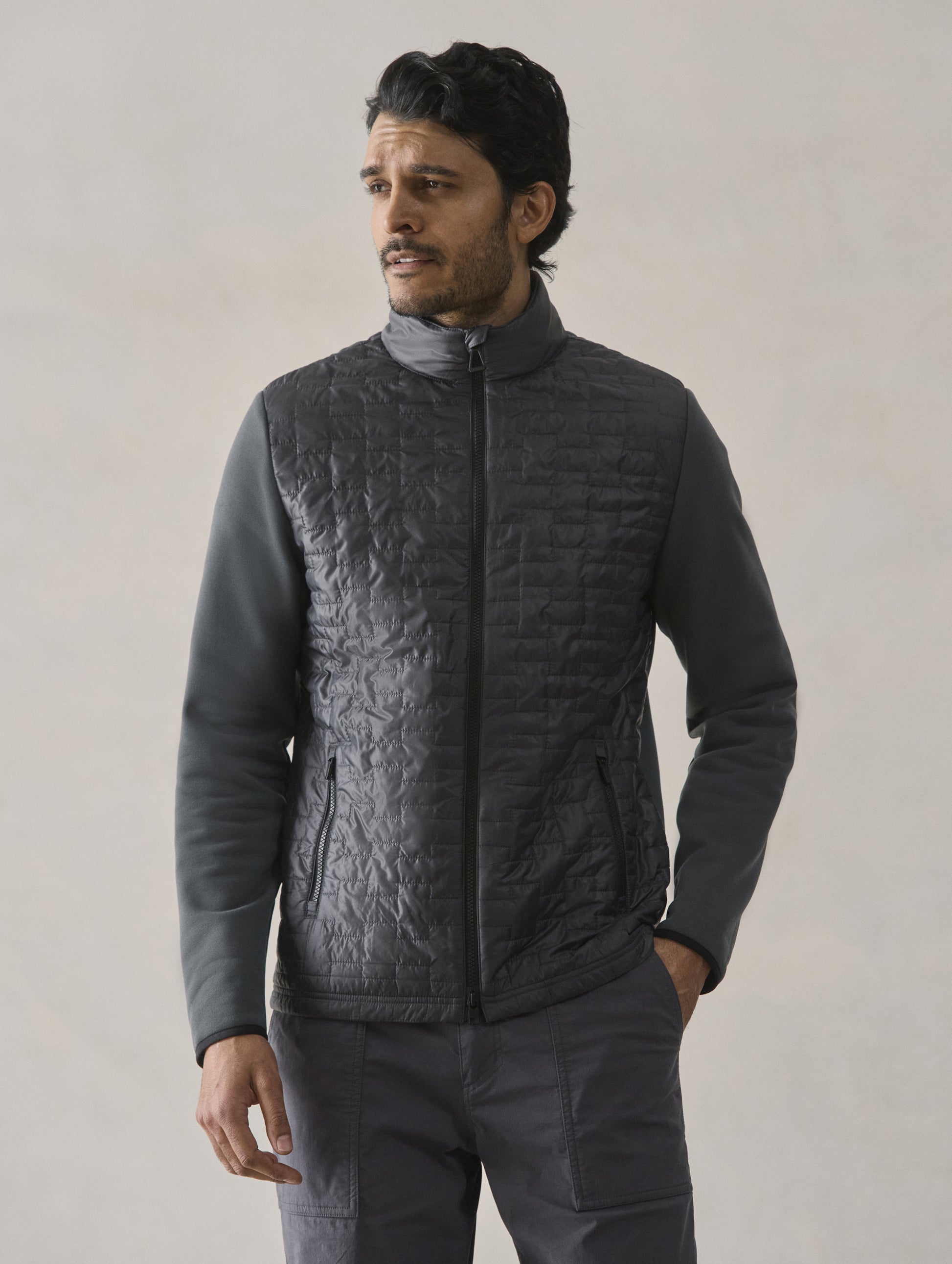 Front upper body view of man wearing Hybrid Tech Full-Zip in Graphite from AETHER Apparel.
