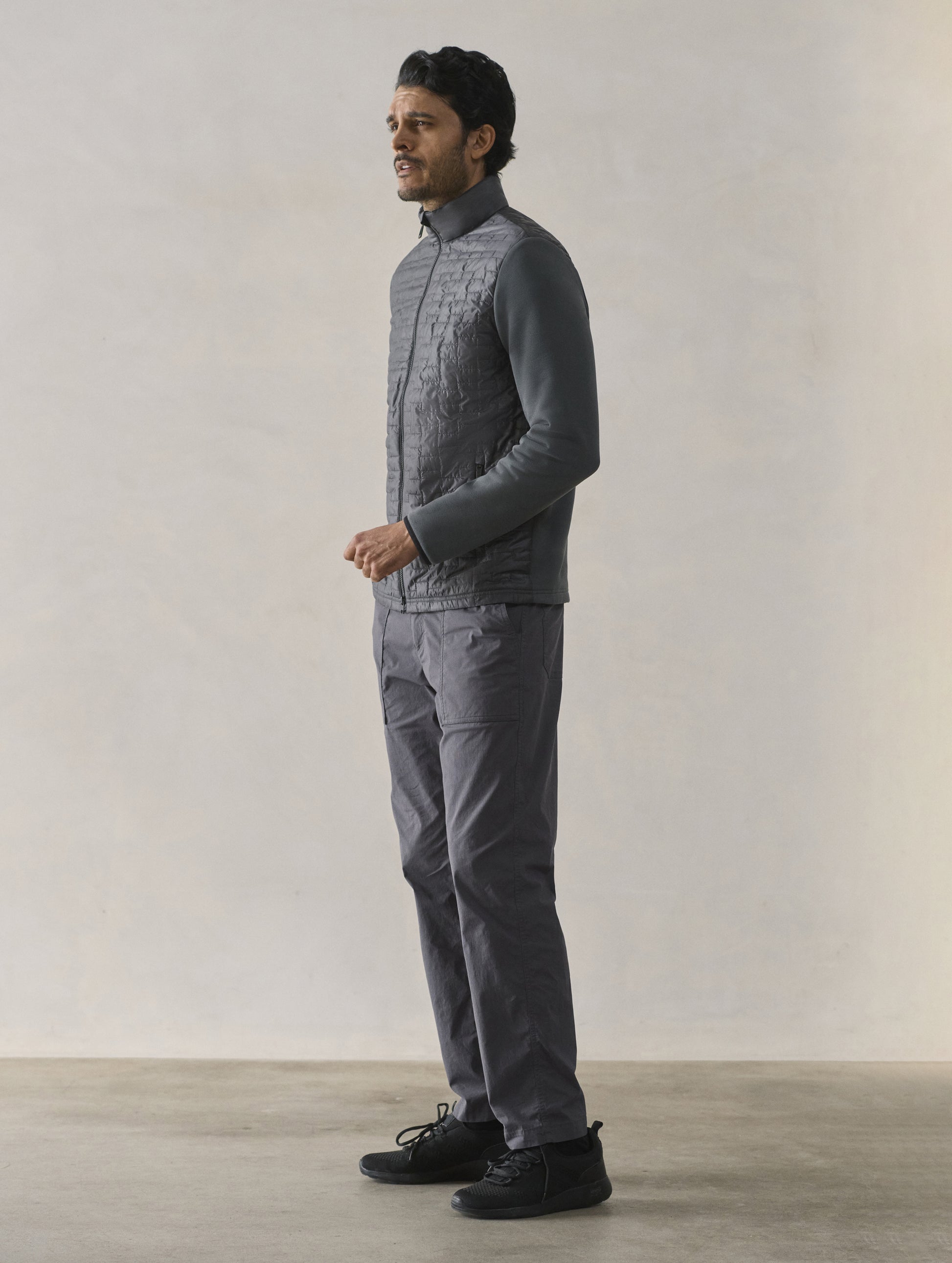 Front 3/4 full-body view of man wearing Hybrid Tech Full-Zip in Graphite from AETHER Apparel.