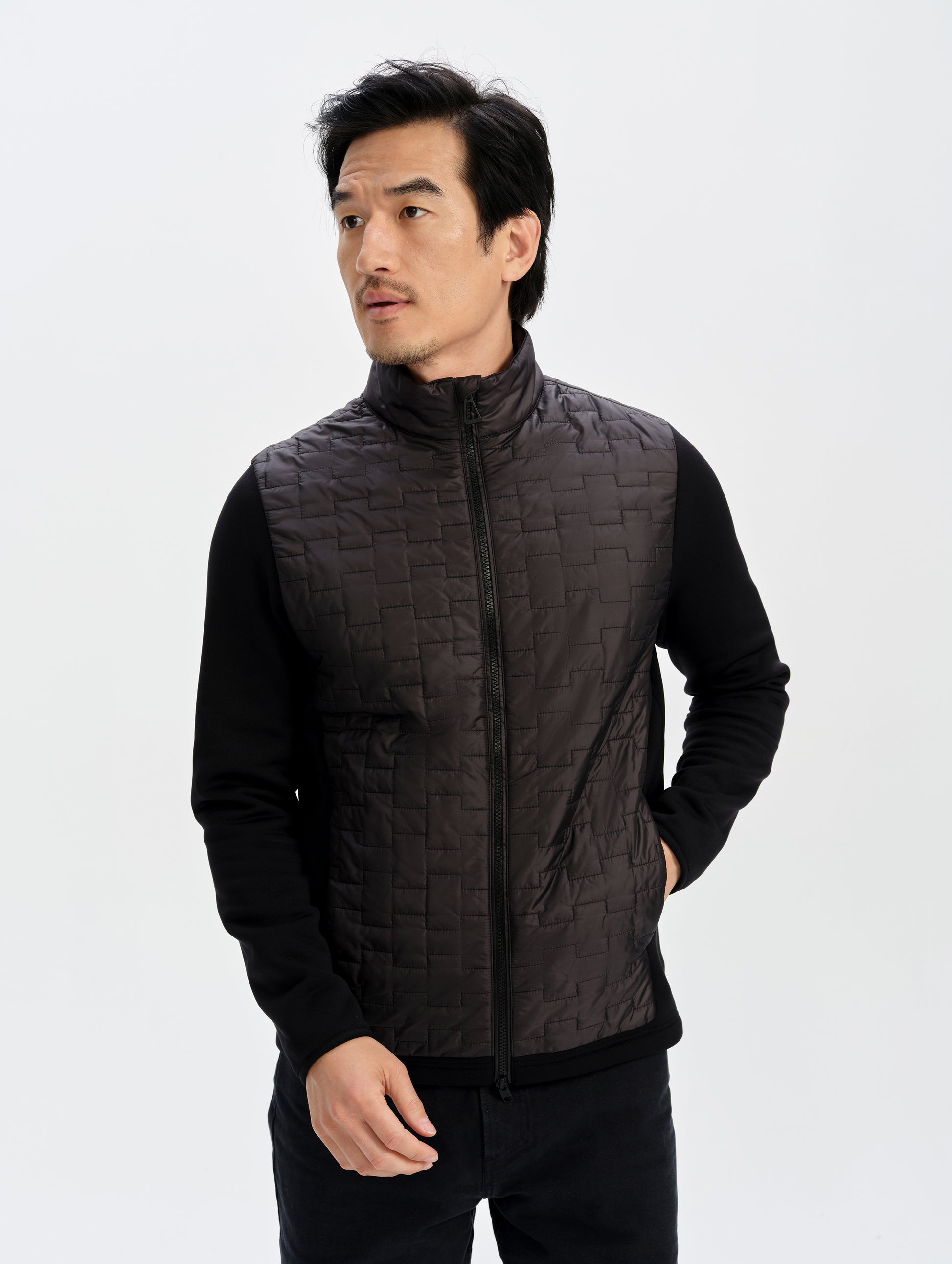Front upper-body view of man wearing the Hybrid Tech Full-Zip 2.0 in Onyx Black from AETHER Apparel. 