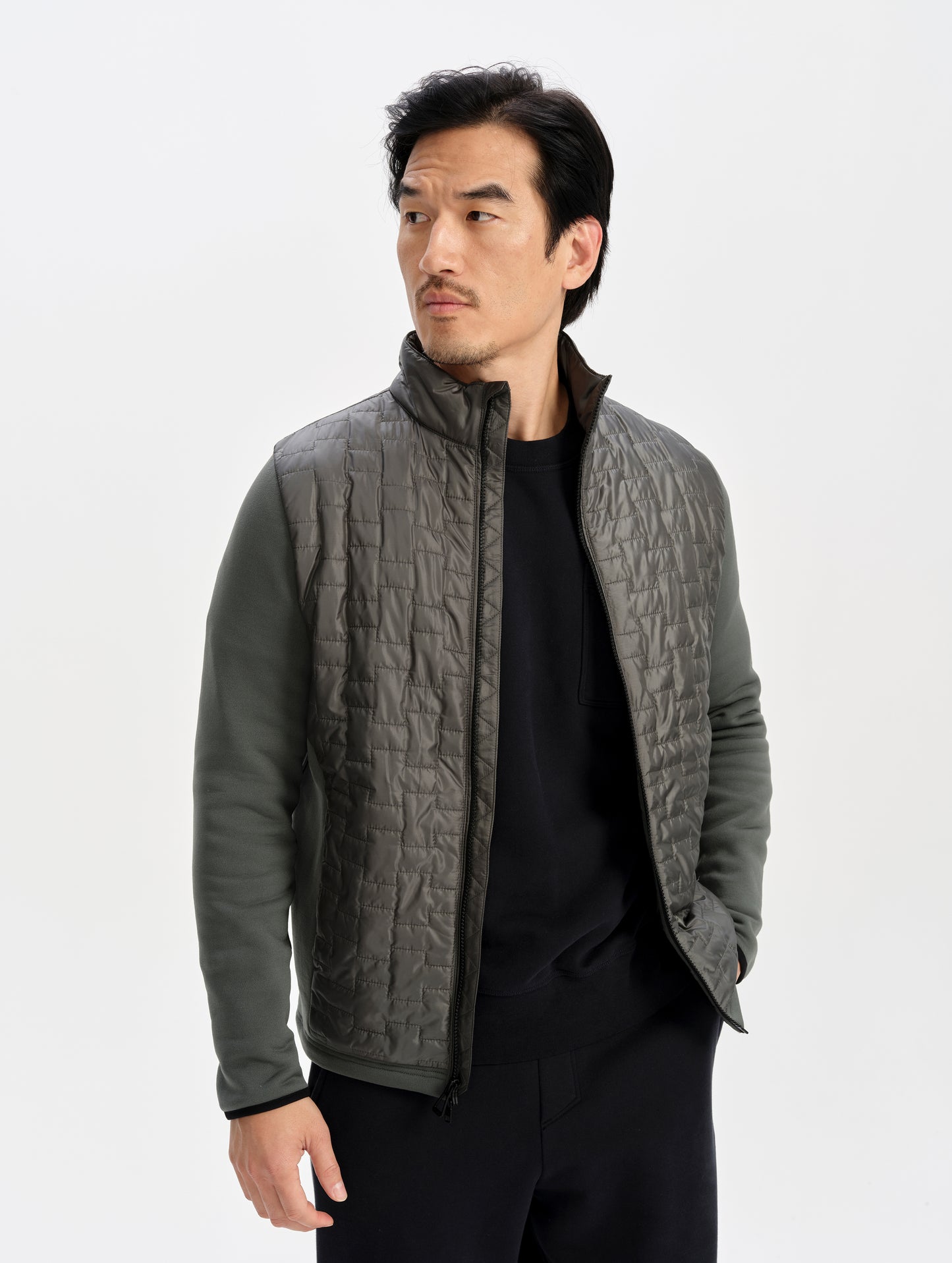 Front upper-body view of man wearing the Hybrid Tech Full-Zip 2.0 in Saville Green from AETHER Apparel. 