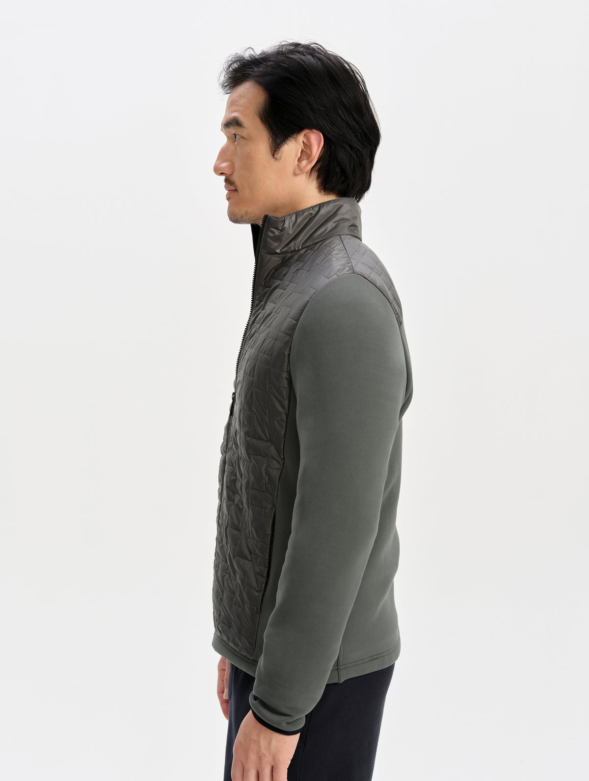 Side profile upper-body view of man wearing the Hybrid Tech Full-Zip 2.0 in Saville Green from AETHER Apparel. 