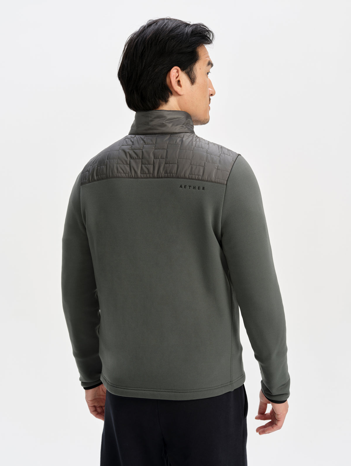 Rear upper-body view of man wearing the Hybrid Tech Full-Zip 2.0 in Saville Green from AETHER Apparel. 