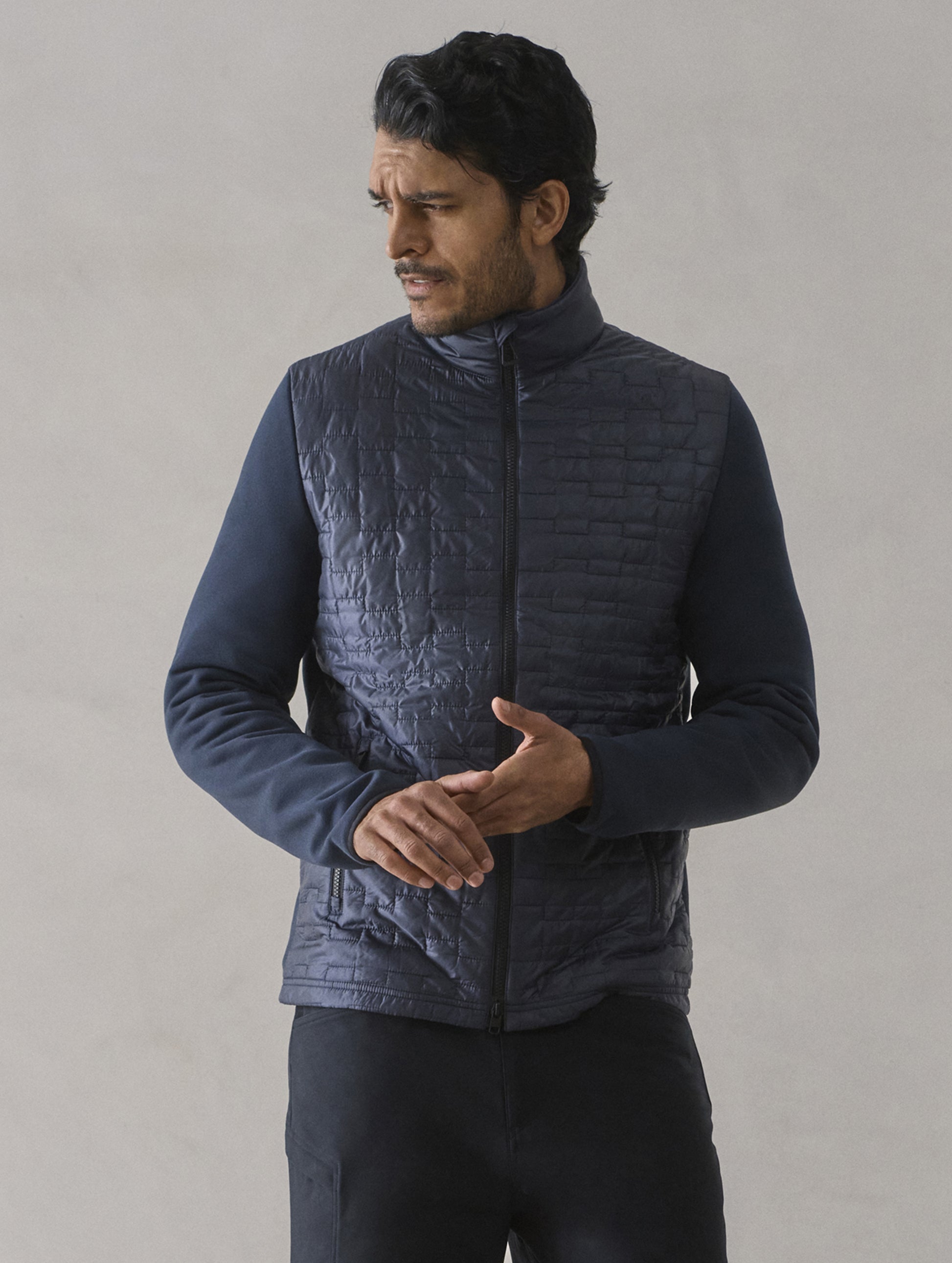 Front upper body view of man wearing Hybrid Tech Full-Zip in Total Eclipse dark blue from AETHER Apparel.