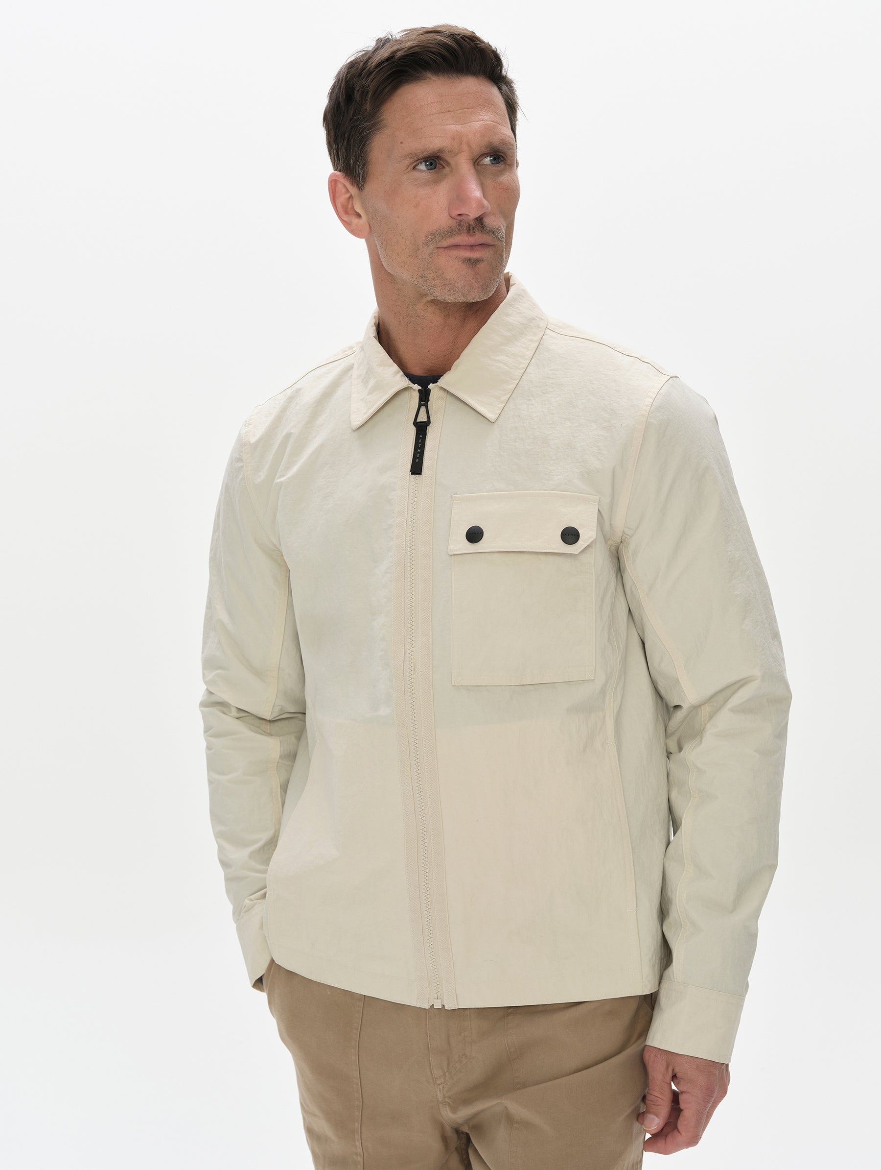 Front, upper-body view of man wearing the Landon Jacket in Onyx Black from AETHER Apparel.