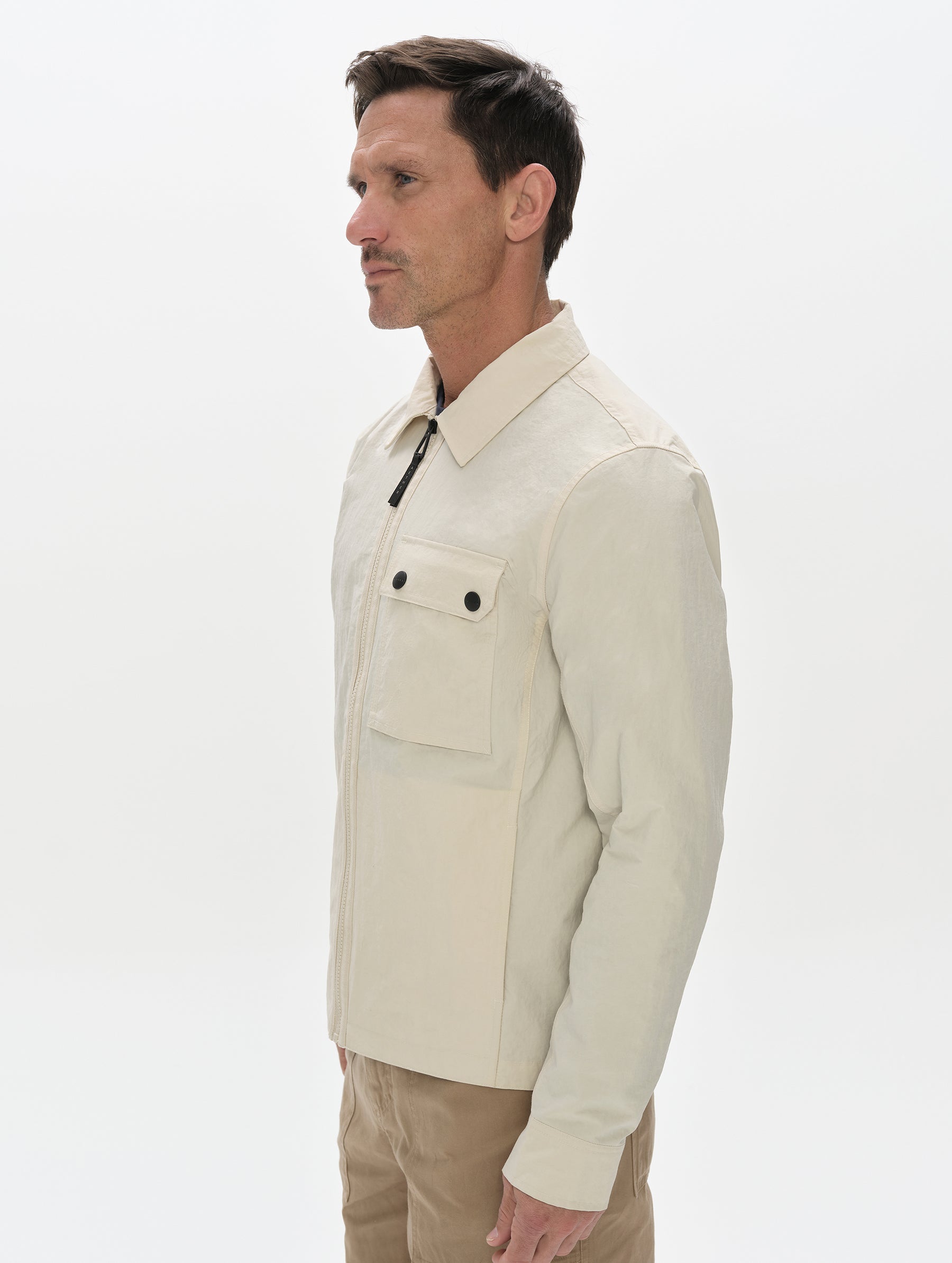 Front, 3/4, upper-body view of man wearing the Landon Jacket in Onyx Black from AETHER Apparel.