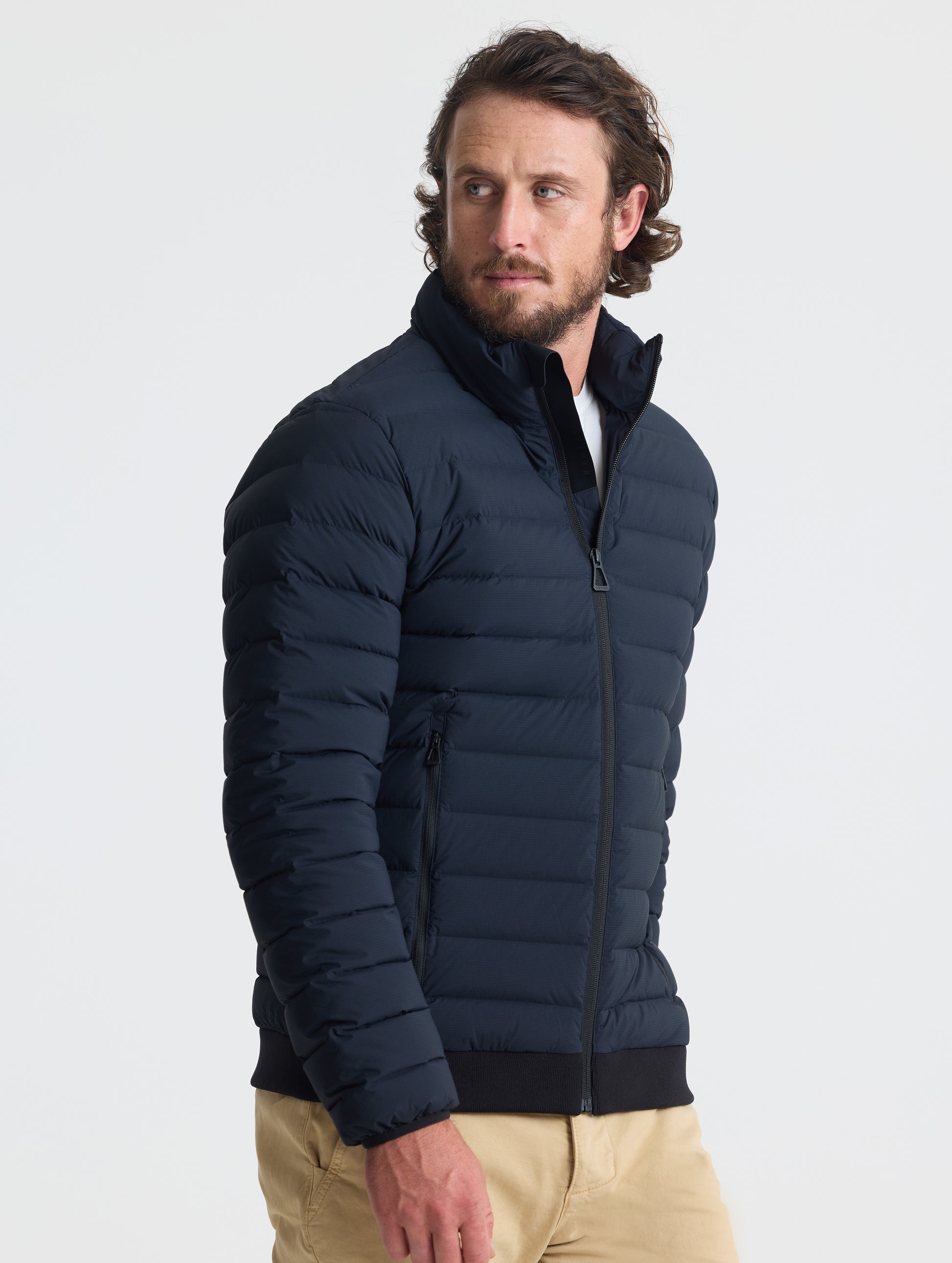 Angled view of man wearing Launch Jacket in Onyx Black from AETHER Apparel.