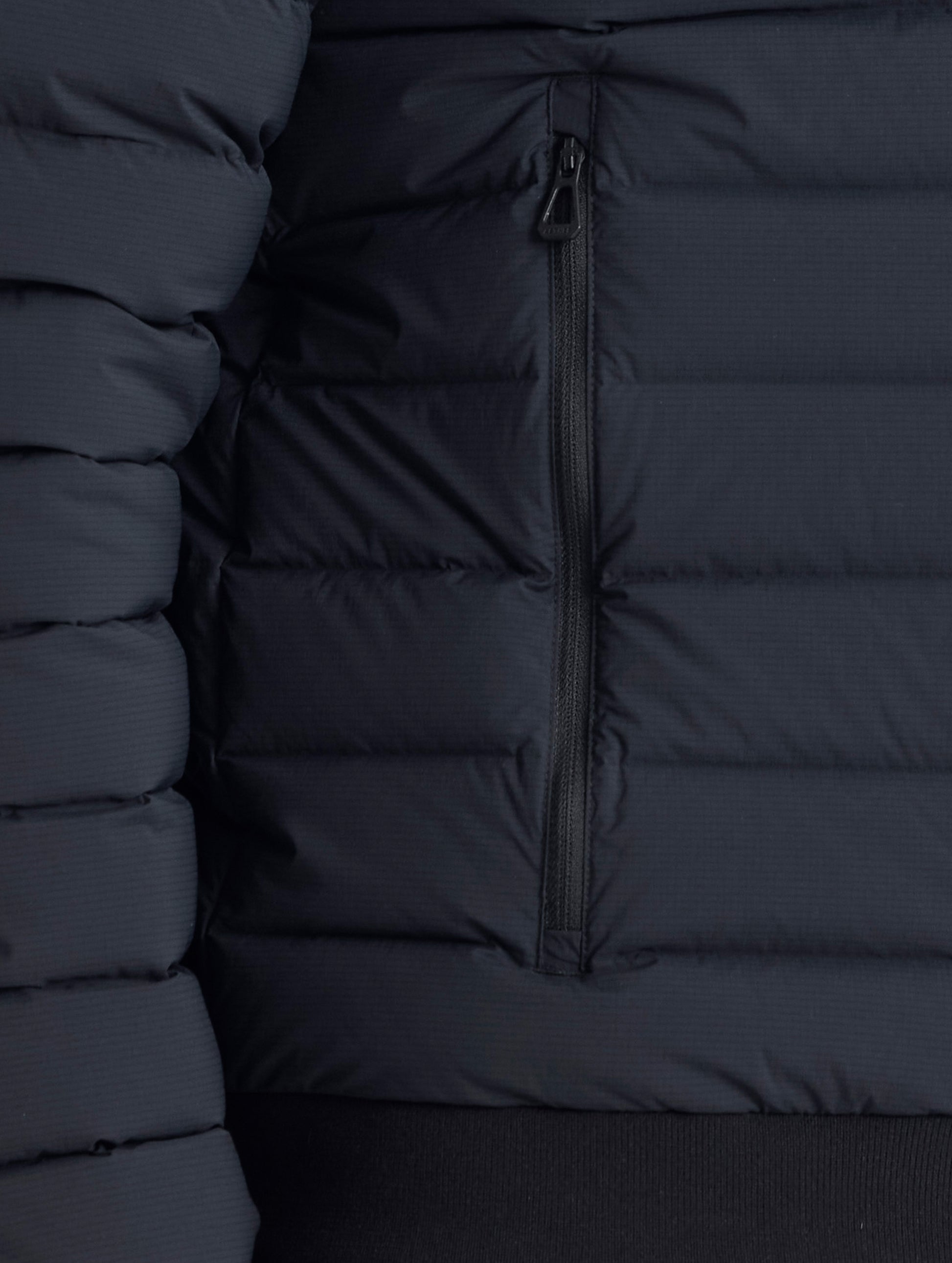 Closeup view of wearer's right zipper hand pocket of Launch Jacket in Onyx Black from AETHER Apparel.