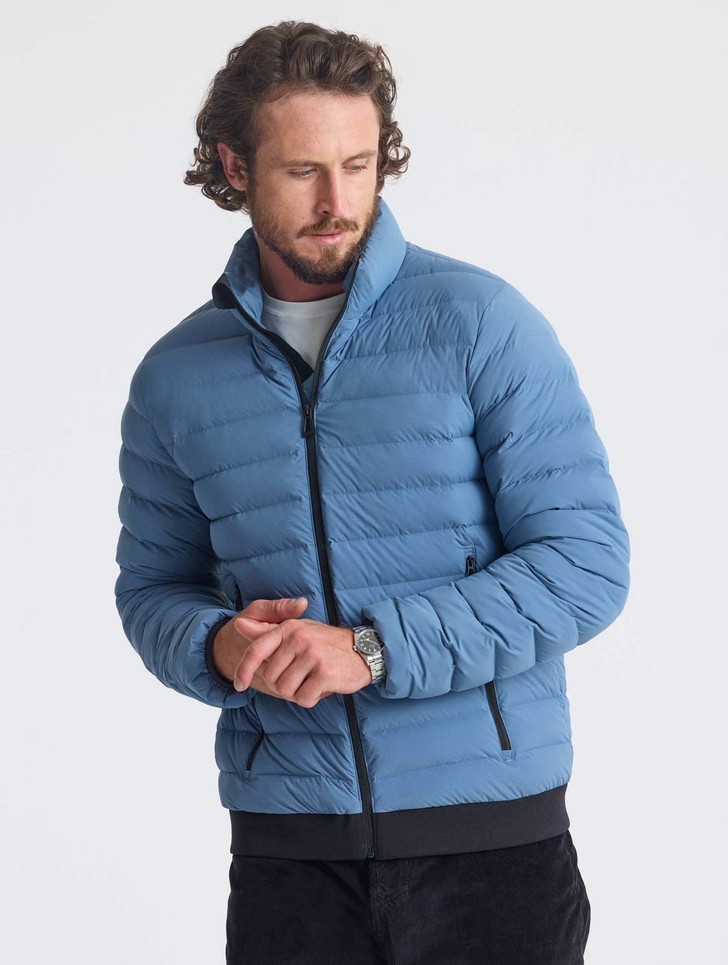 Front view of man wearing Prospect Packable Down Jacket in Portal Blue from AETHER Apparel.