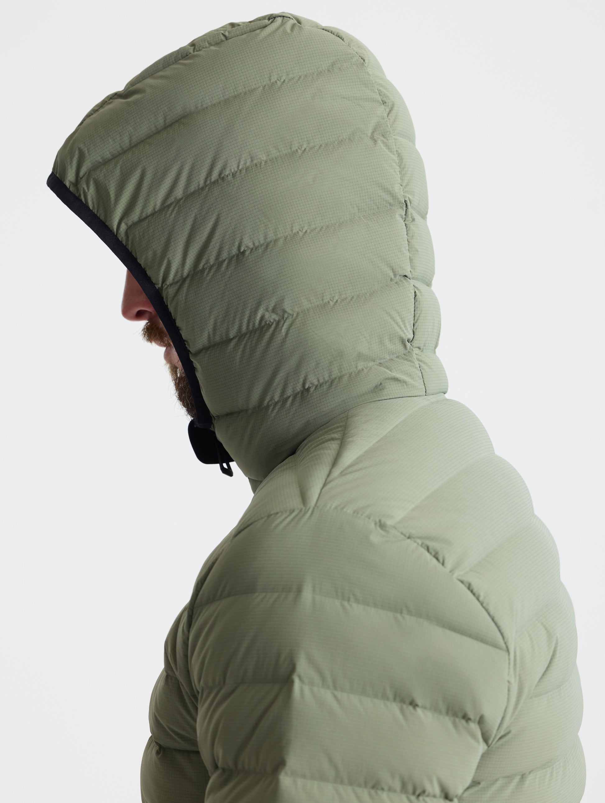 Closeup left profile view of man wearing hood of Launch Full-Zip Hooded Jacket in Fern Green from AETHER Apparel.