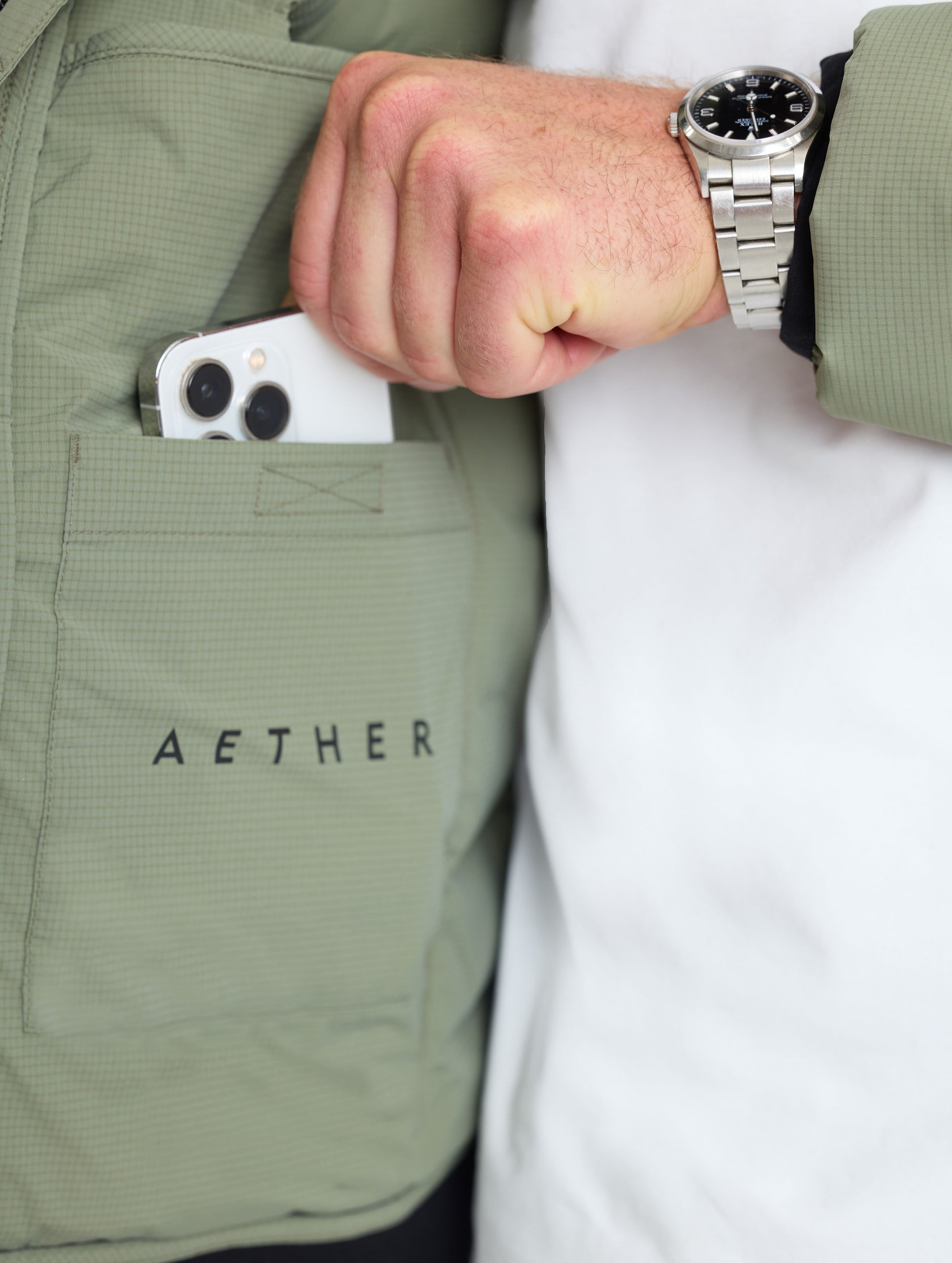 Closeup view of wearer's left drop pocket of Launch Full-Zip Hooded Jacket in Fern Green from AETHER Apparel.
