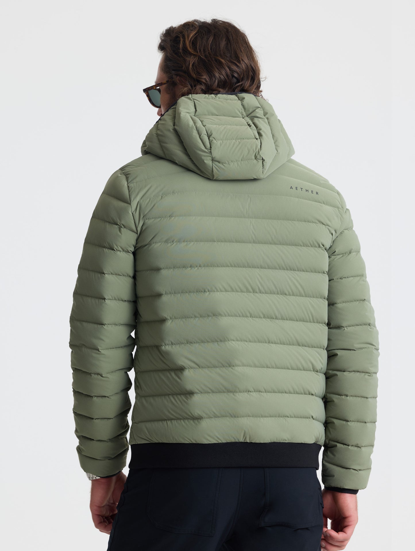Rear view of man wearing Launch Full-Zip Hooded Jacket in Fern Green from AETHER Apparel.