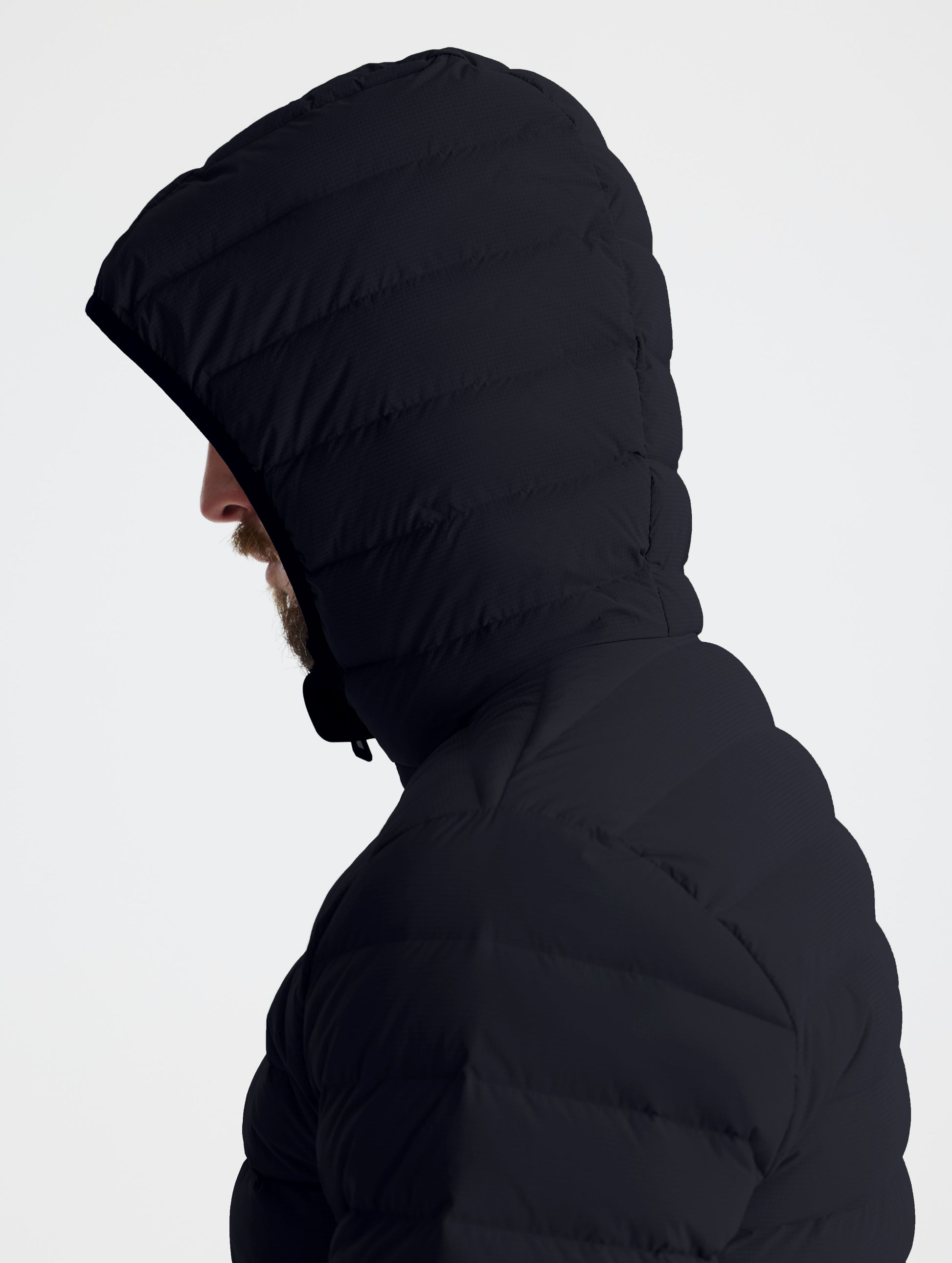 Closeup left profile view of man wearing hood of Launch Full-Zip Hooded Jacket in Onyx Black from AETHER Apparel.