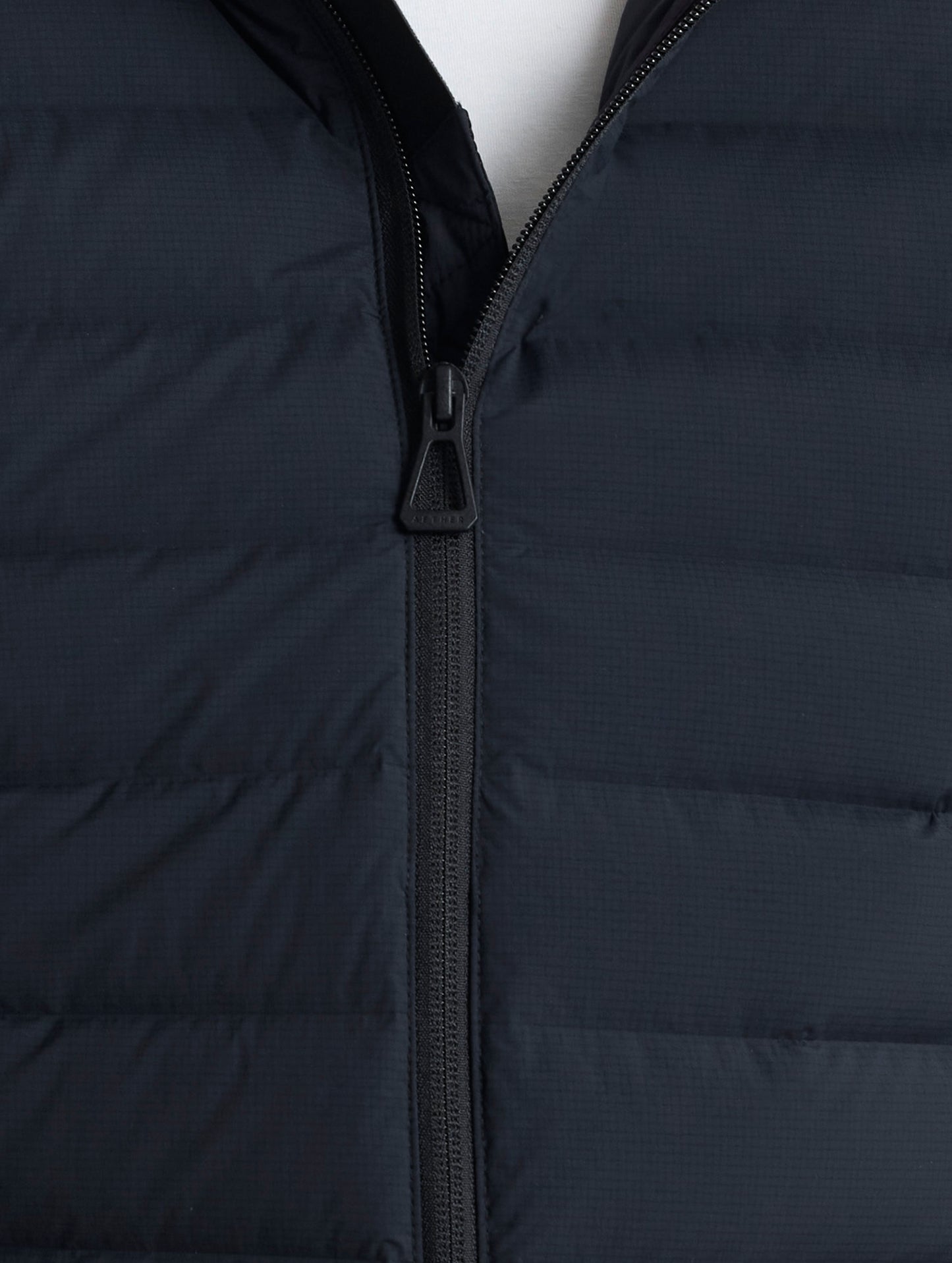 Closeup detail view of front zipper of Launch Full-Zip Hooded Jacket in Onyx Black from AETHER Apparel.
