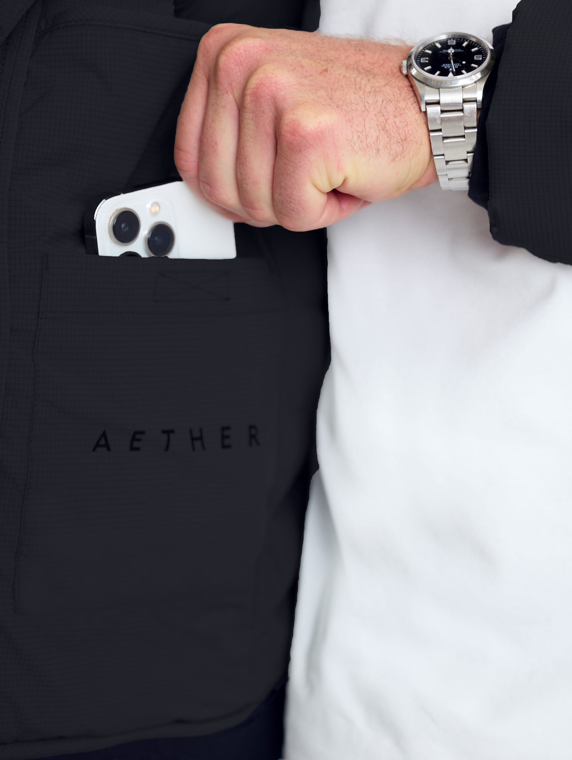 Closeup rear detail view of wearer's left drop pocket of Launch Full-Zip Hooded Jacket in Onyx Black from AETHER Apparel.