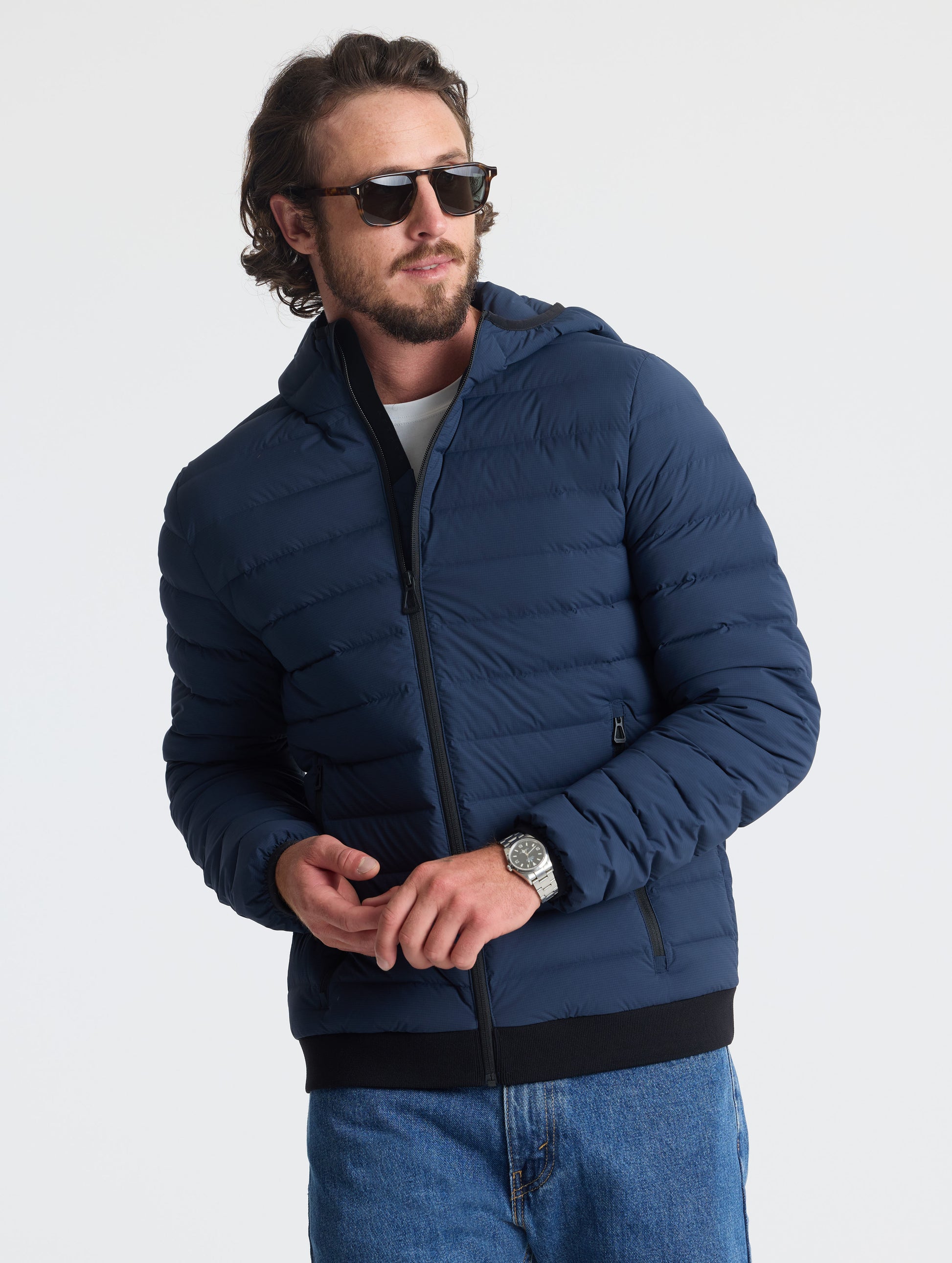 Front upper body view of man wearing Launch Full-Zip Hooded Jacket in Total Eclipse dark blue from AETHER Apparel.