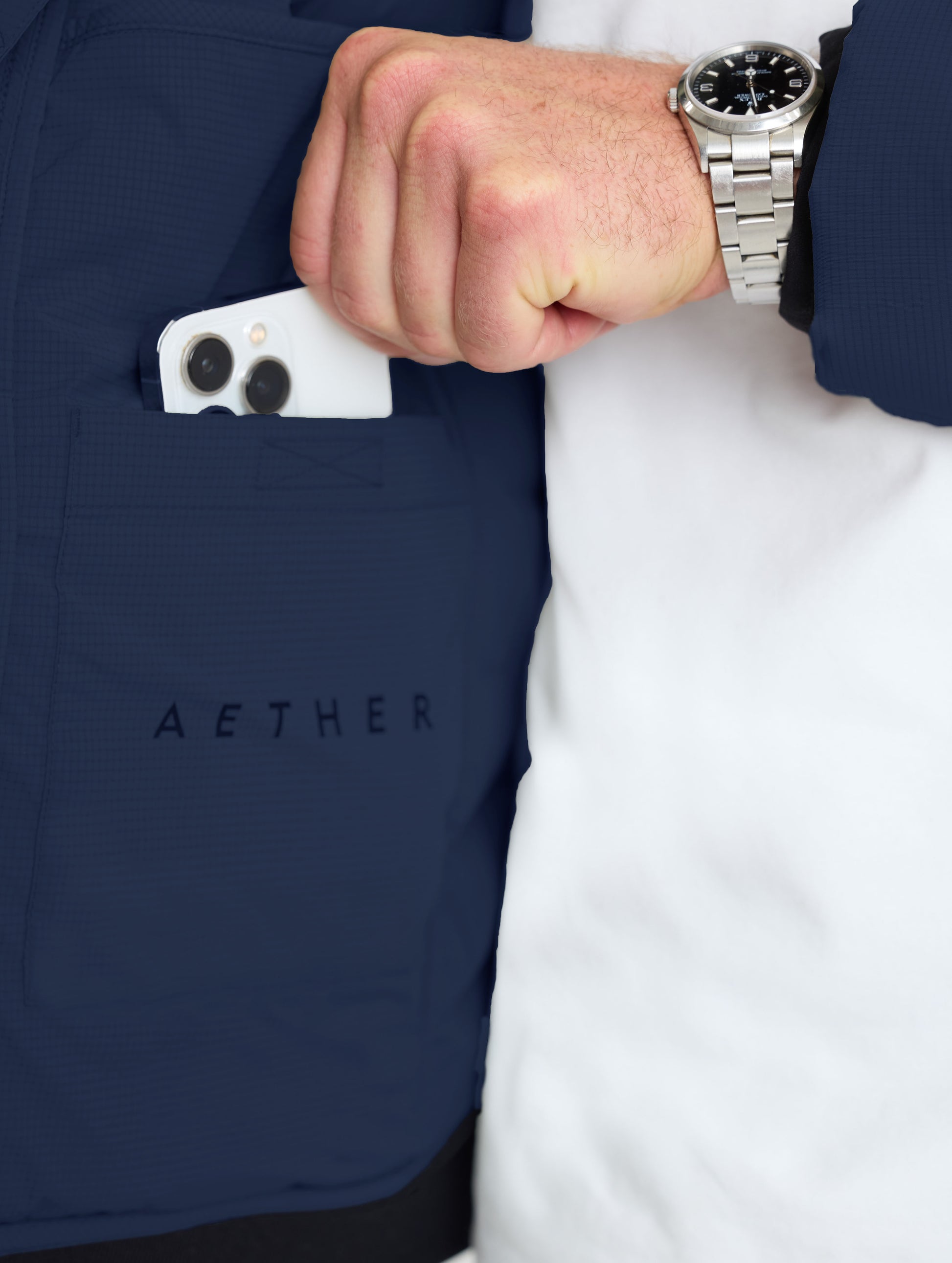 Closeup view of wearer's left drop pocket of Launch Full-Zip Hooded Jacket in Total Eclipse dark blue from AETHER Apparel.