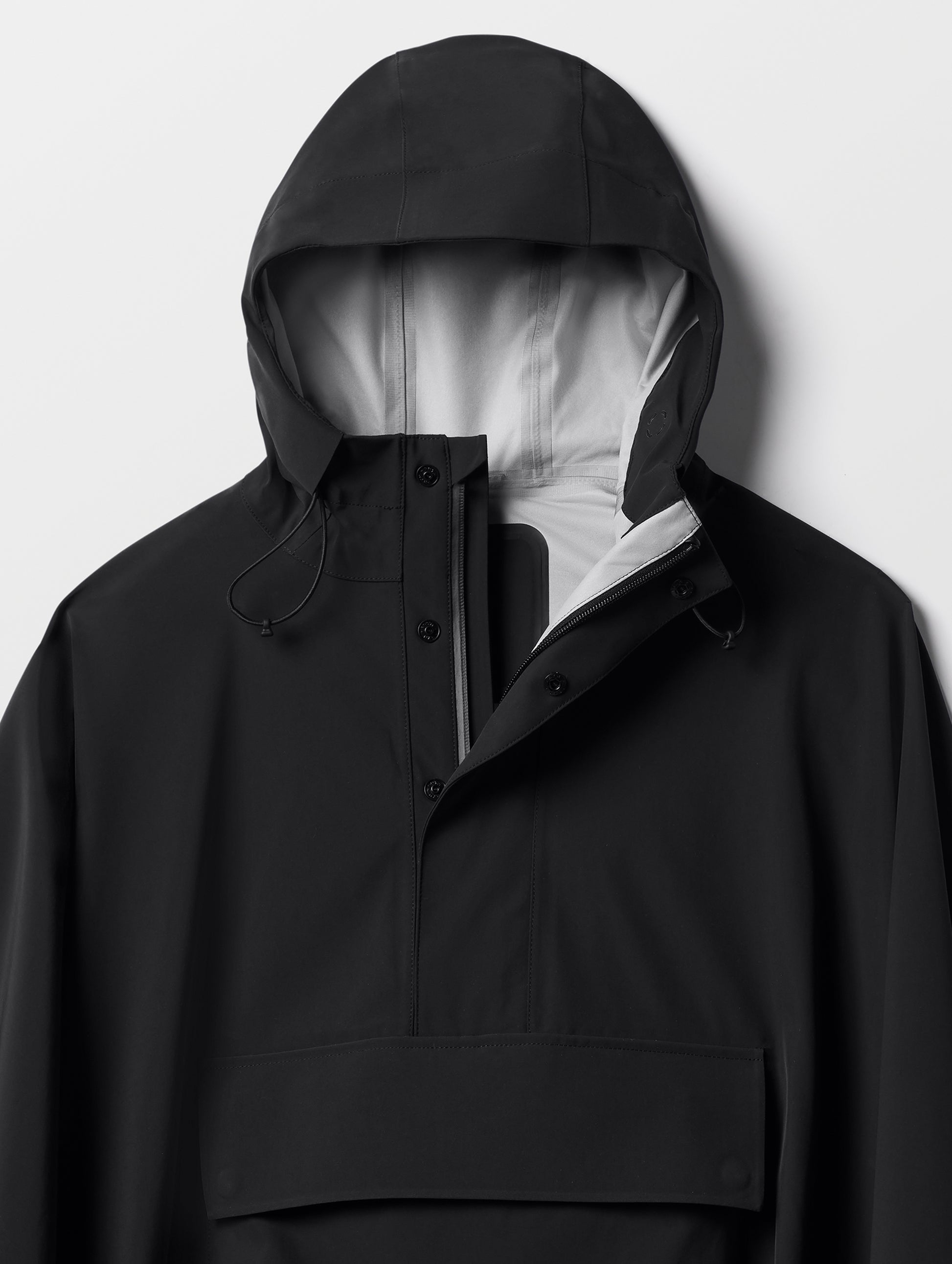 Closeup detailed view of the three-piece hood and quarter-length center-front zipper on the Line Poncho in Onyx Black from AETHER Apparel.