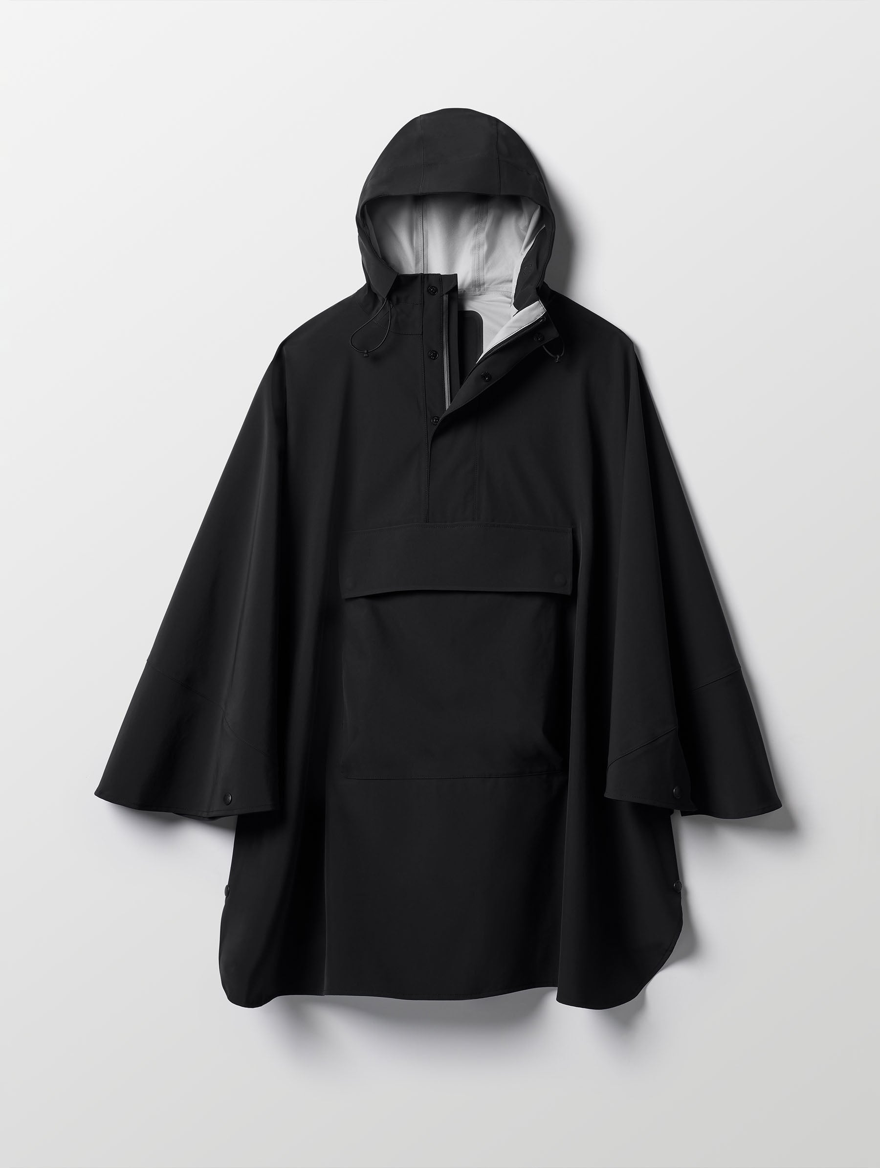 Flat lay of the Line Poncho in Onyx Black from AETHER Apparel.
