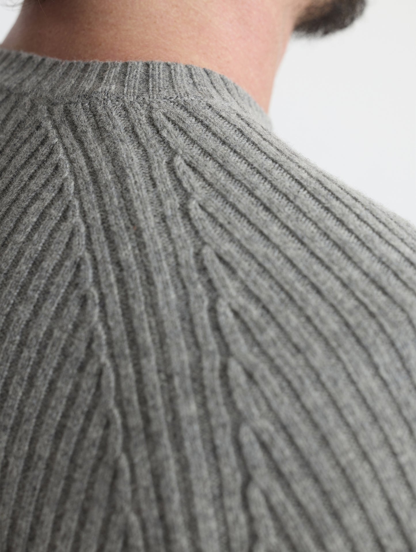 Closeup rear detail view of wearer's right shoulder of Lyon Sweater in Heather Grey from AETHER Apparel. 