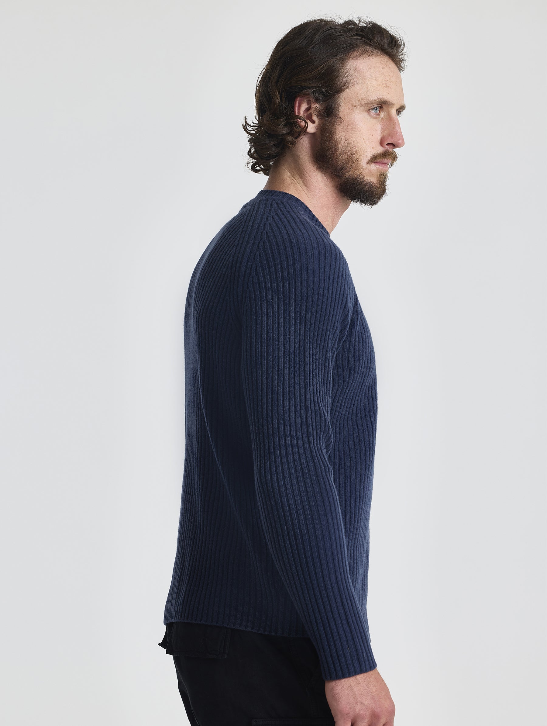 Right profile of man wearing Lyon Sweater in Total Eclipse dark blue from AETHER Apparel.