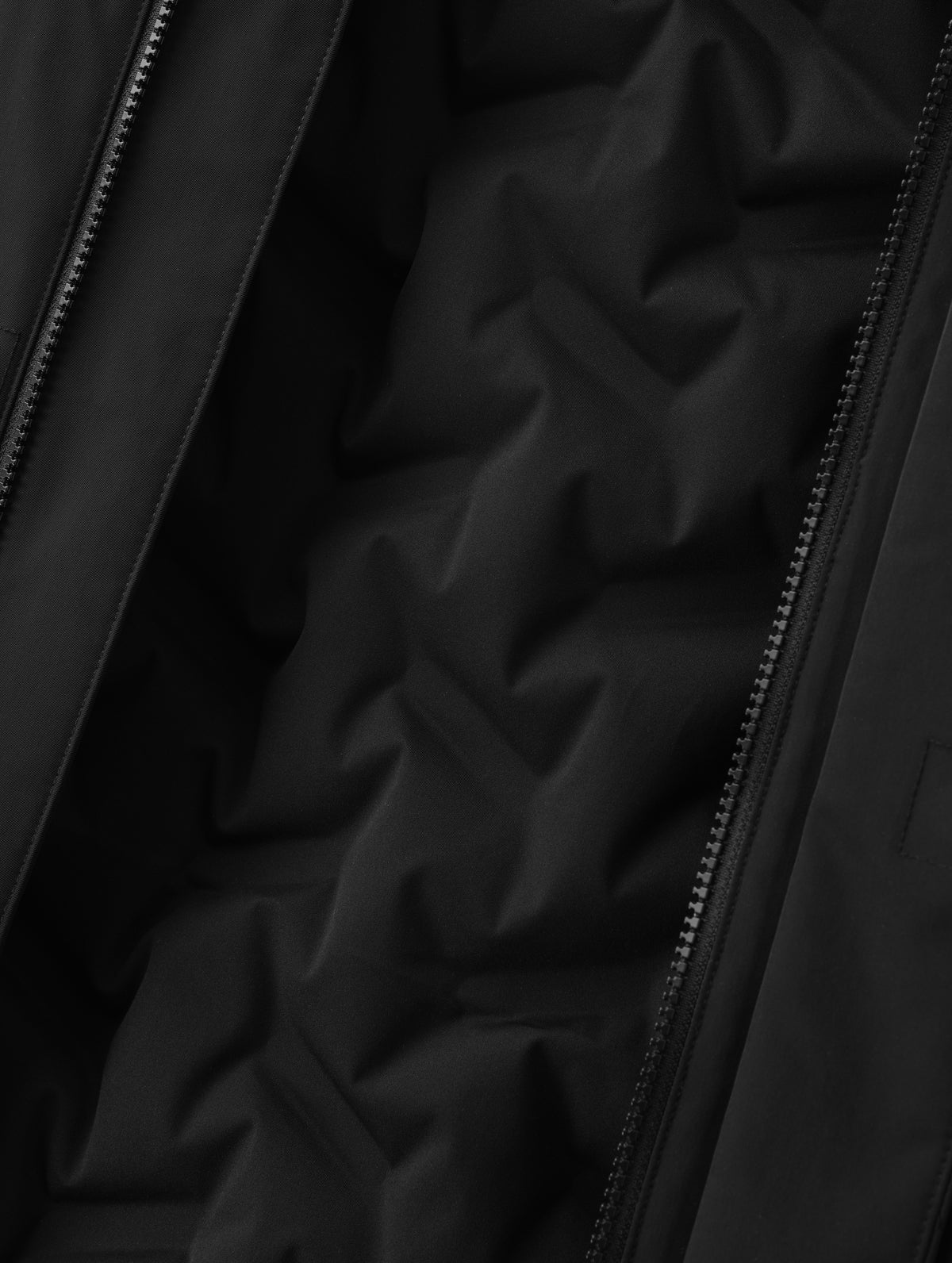 Closeup detailed view of the custom bonded insulated baffling inside the Maxwell Insulated Trench in Onyx Black from AETHER Apparel.