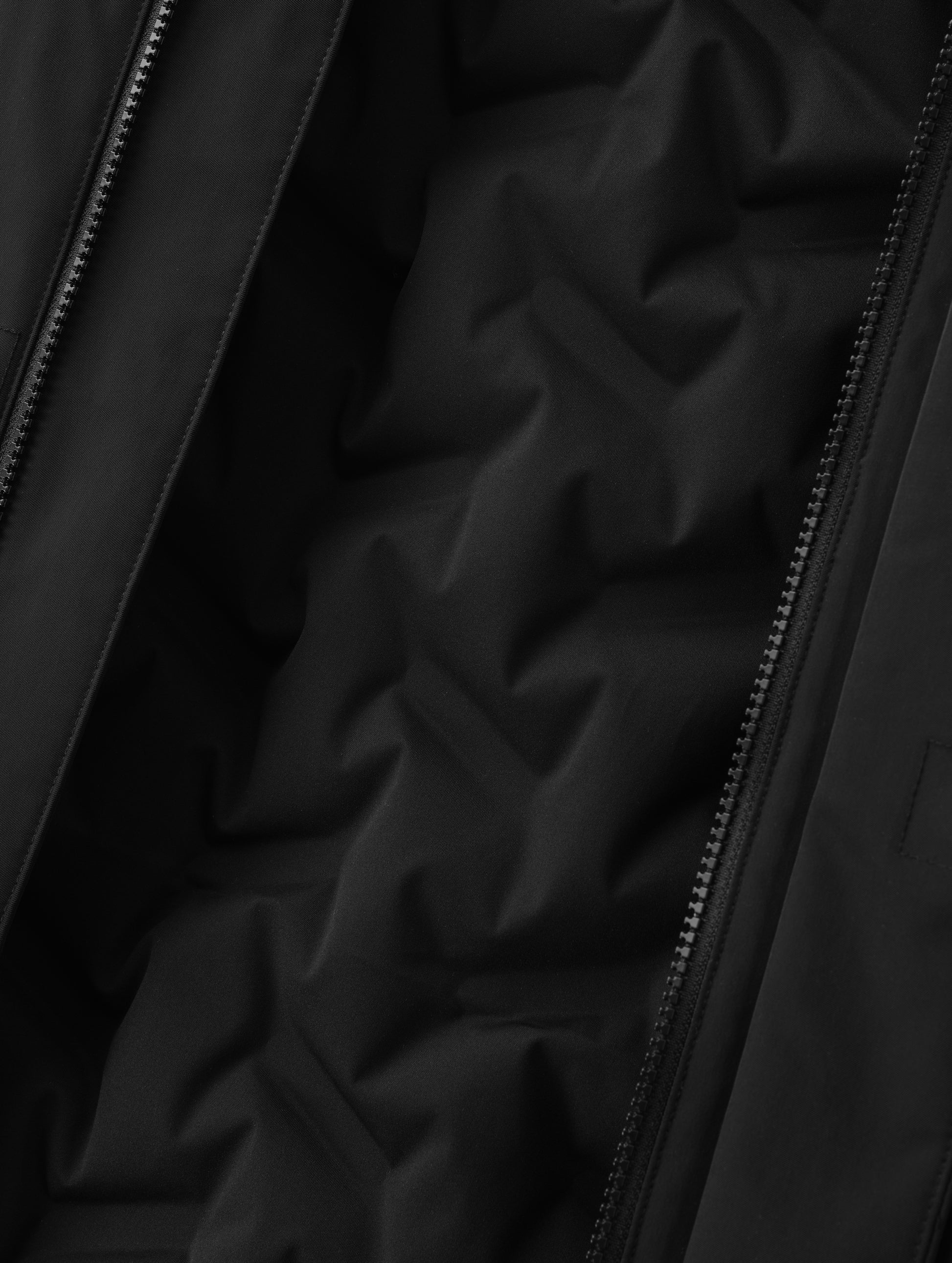 Closeup detailed view of the custom bonded insulated baffling inside the Maxwell Insulated Trench in Onyx Black from AETHER Apparel.