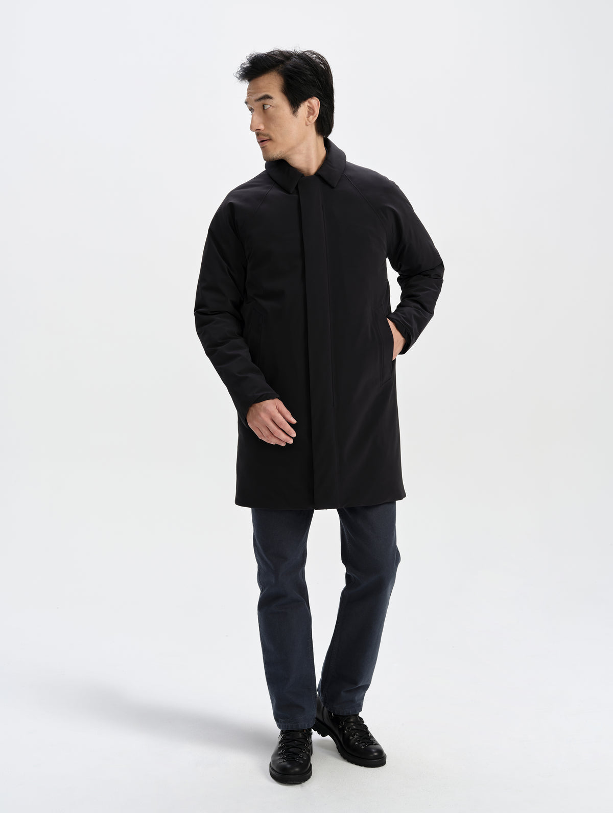 Front full-body view of man wearing the Maxwell Insulated Trench in Onyx Black from AETHER Apparel zipped up.